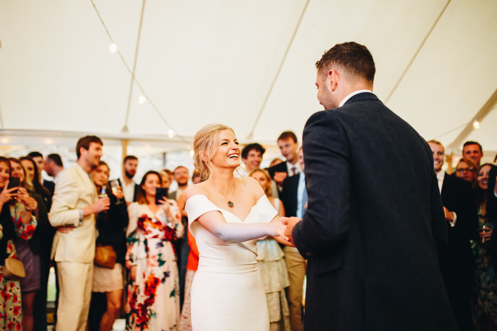 First dance joy, the newlyweds dancing and the bride smiling up at her new husband