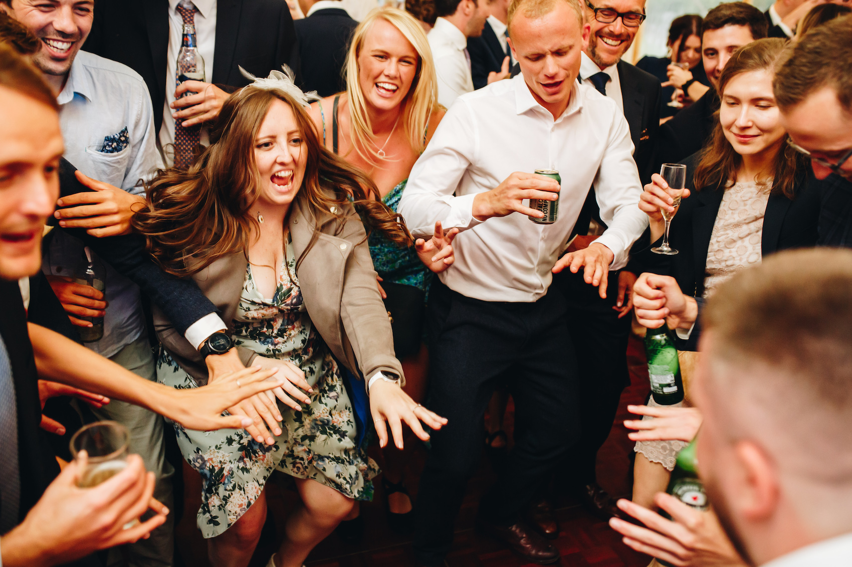 Dancefloor chaos - multiple people stood in a circle with their hands out in front of them, singing along to a song