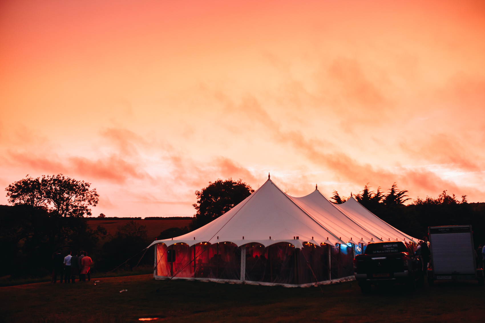 Sunset - a bridge orange sky lighting up the white arched marquee roof