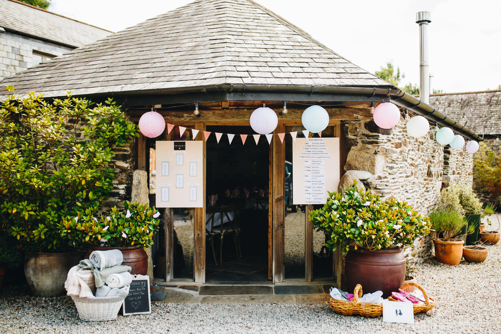The Round House, a building at Wonwood Barton, with bunting and paper lanterns with a table plan by the door