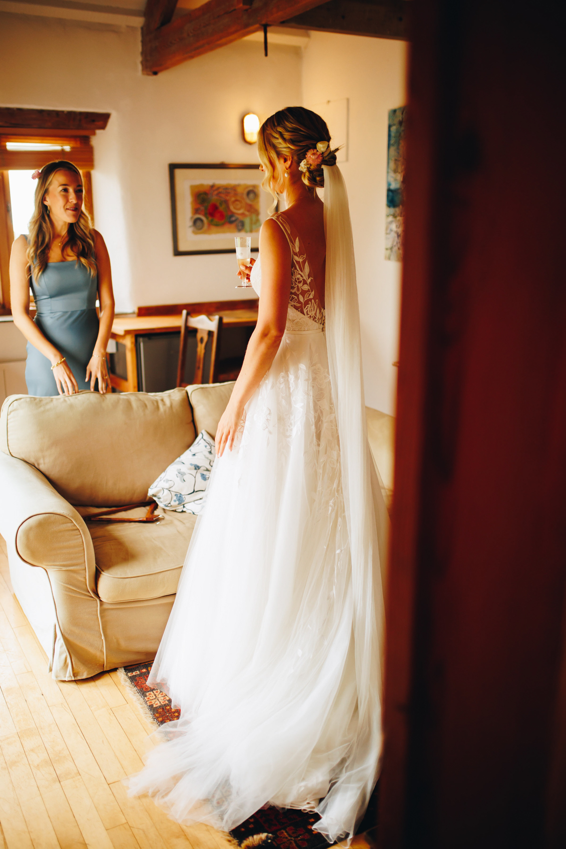 Bride photographed moments before ceremony sharing a moment with her bridesmaid