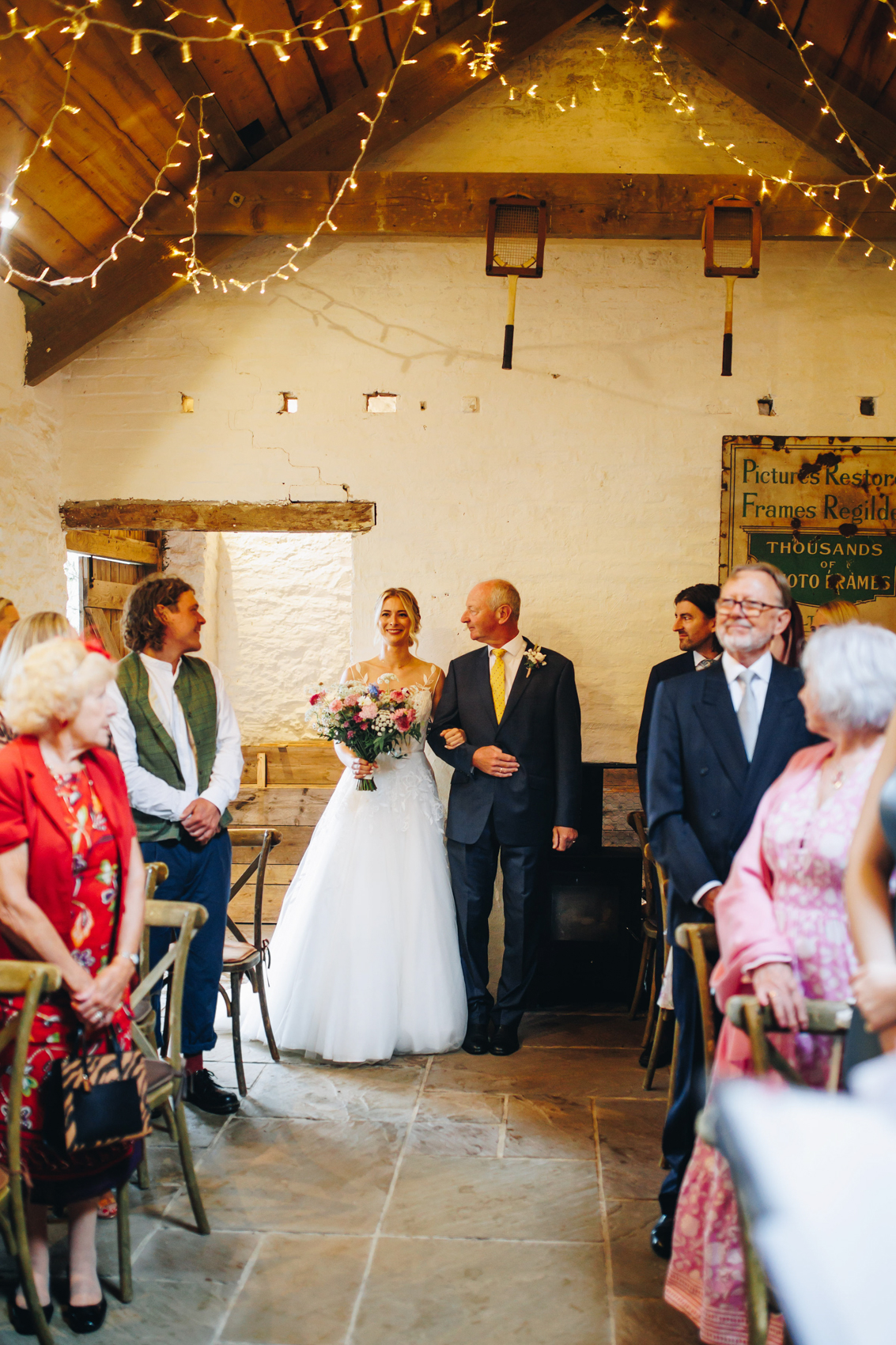 Bride being walked into her ceremony by her smiling dad