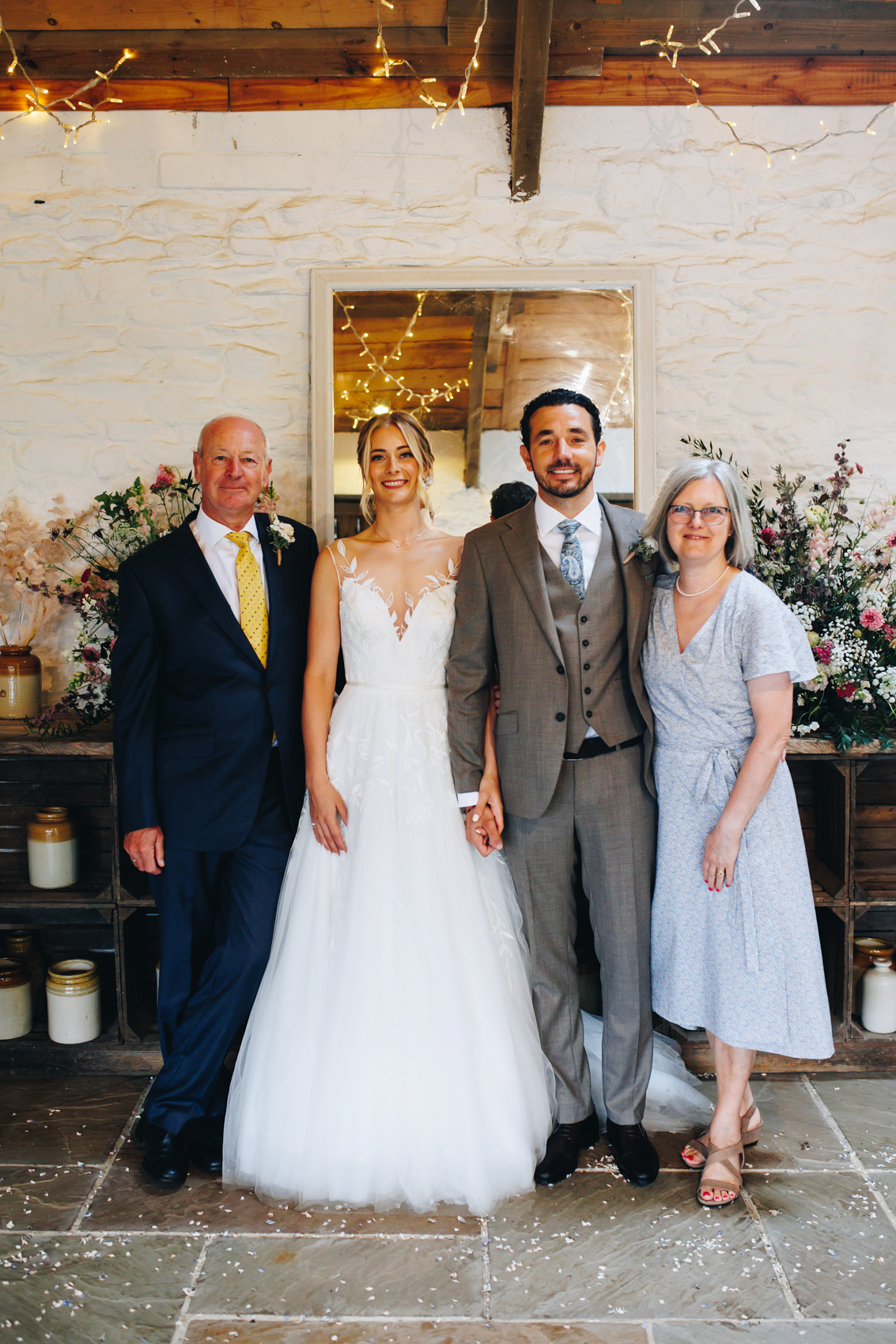 A group photo of the newlyweds with the groom's parents