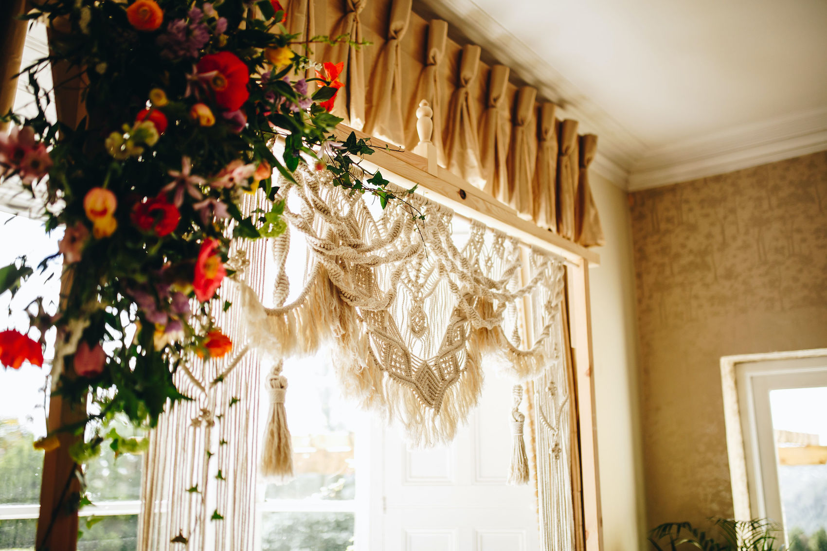 Close up of the handmade macramé wedding arch adorned with florals