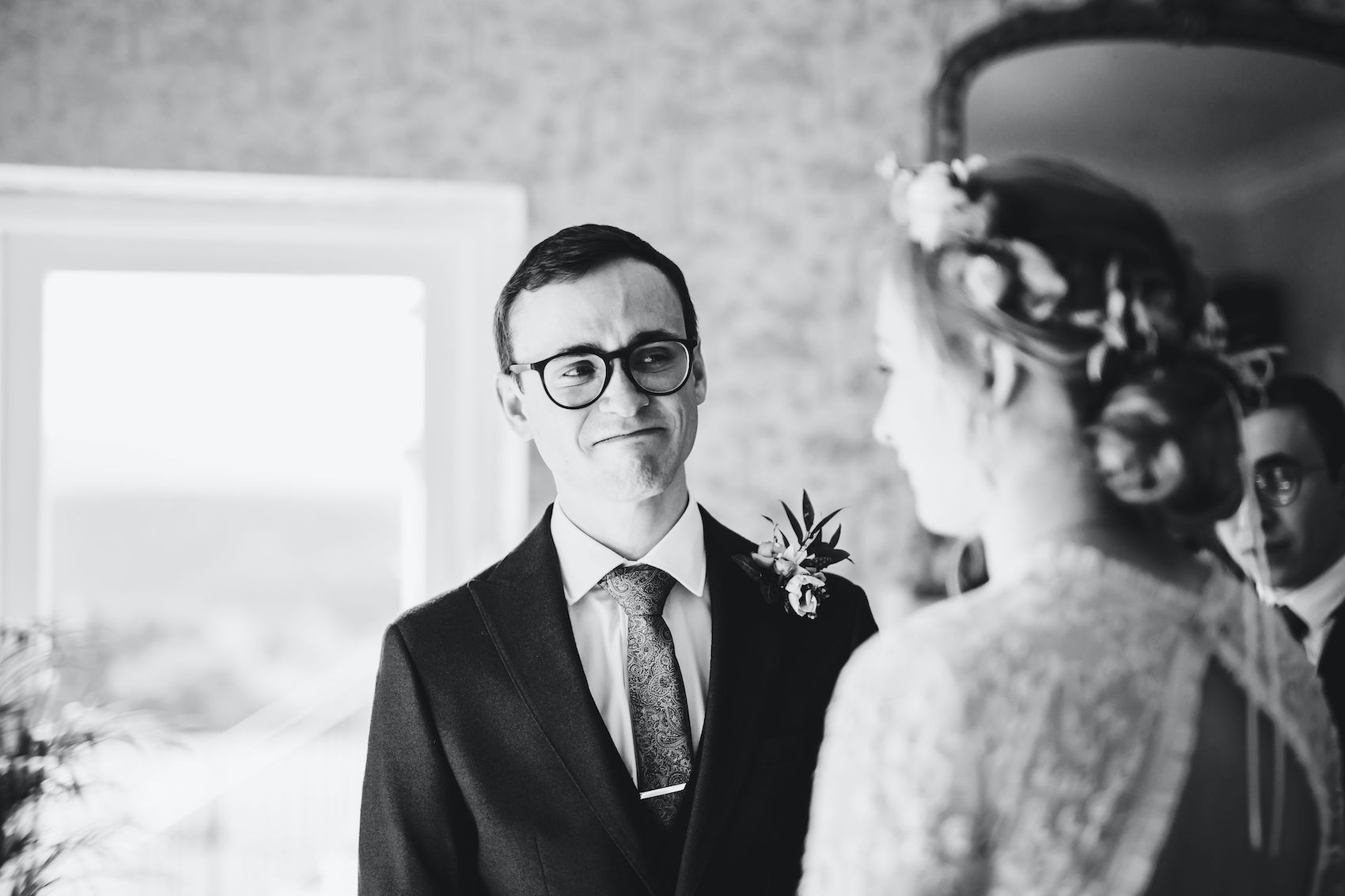Black and white photo of groom teary eyed looking at his new wife