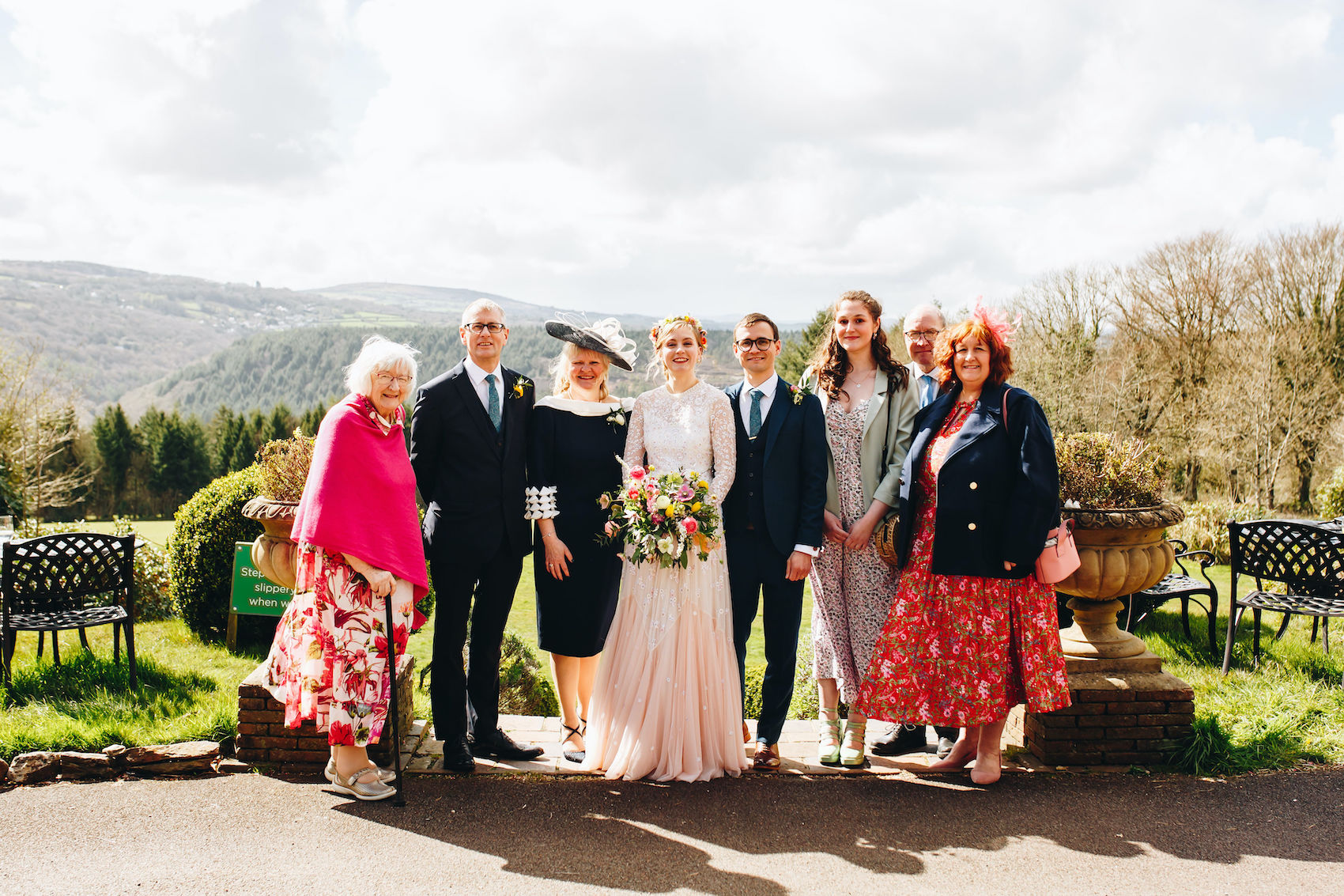 Bride and groom smile with family for a family group photo