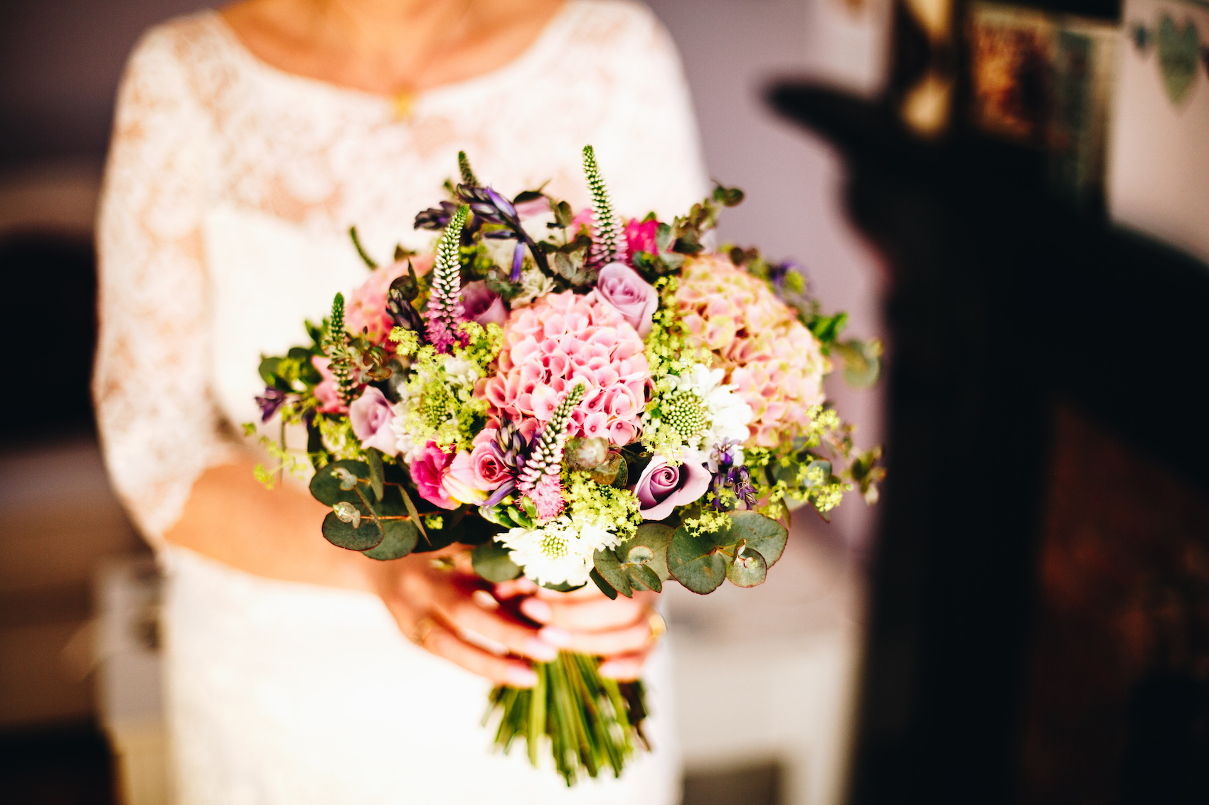 Bridal bouquet with pink and purple florals, being held by the bride