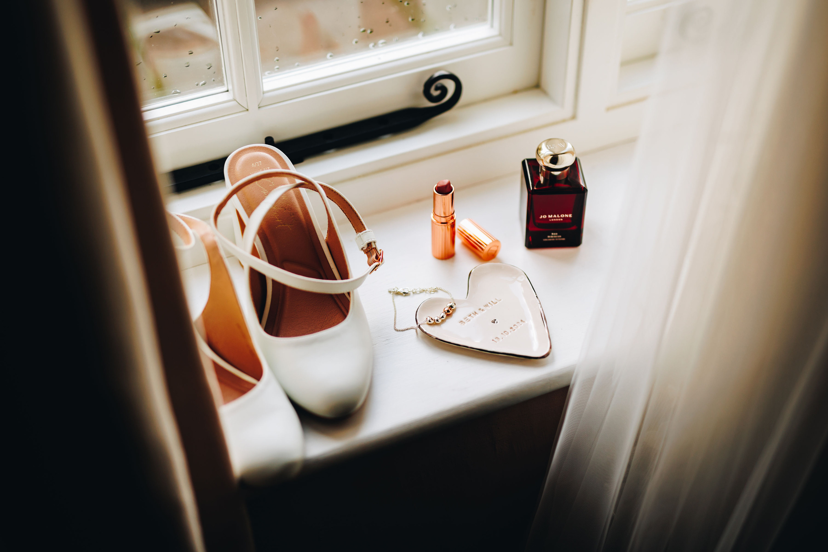 Close up of bride's details - wedding shoes, lipstick, jewellery and perfume