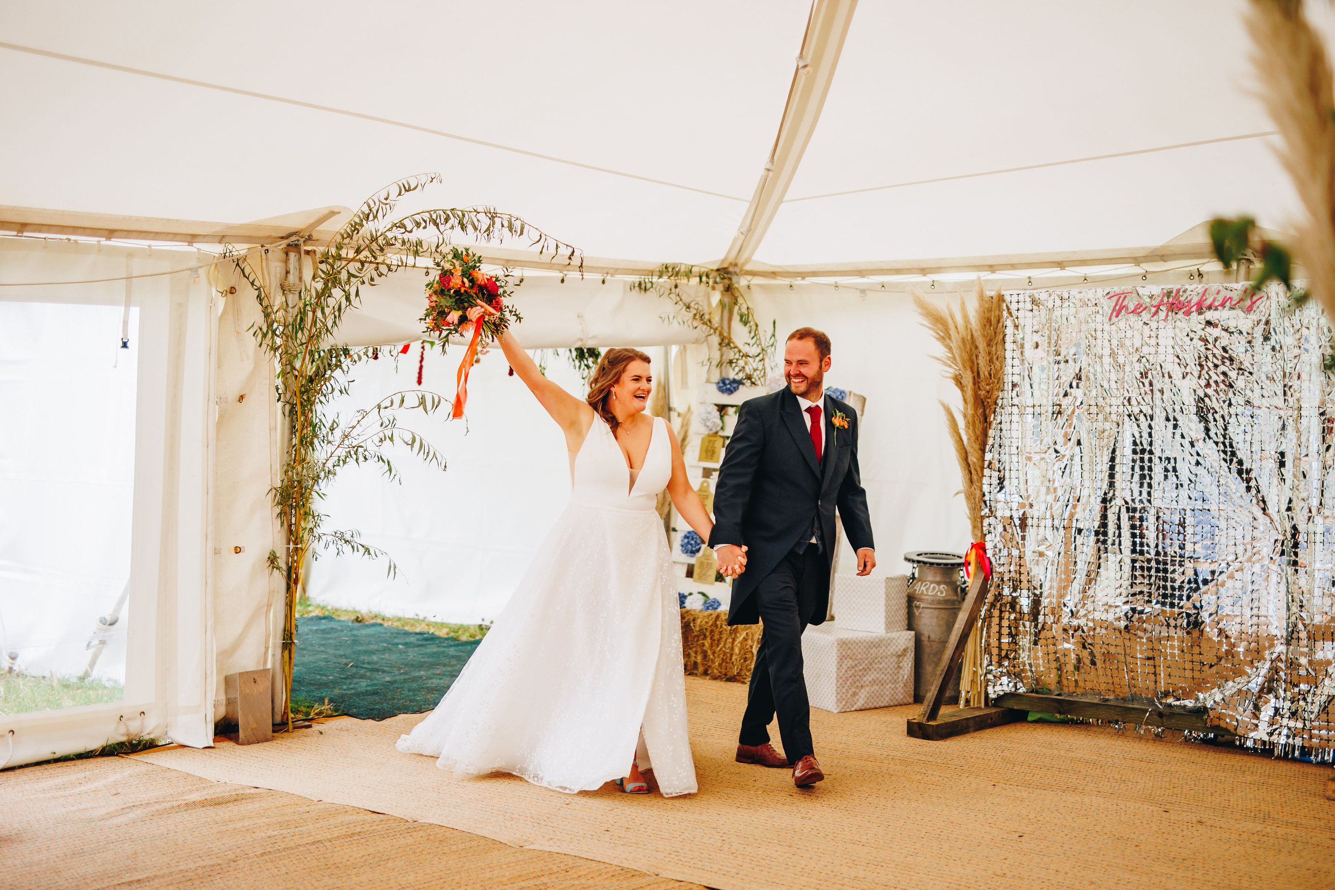 Bride and Groom enter wedding reception with arms up celebrating