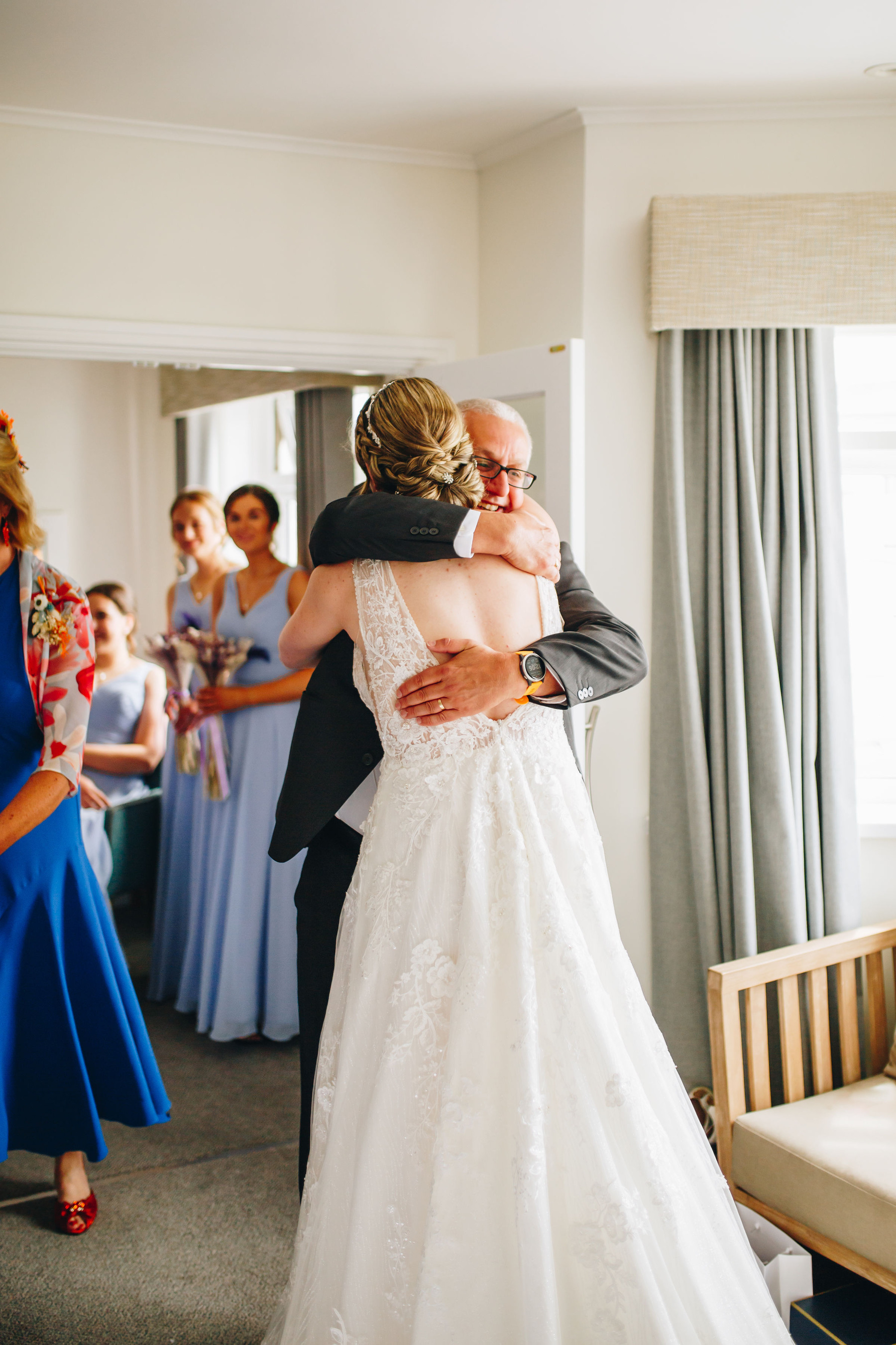 Bride and dad hug after he's seen her for the first time in her wedding dress