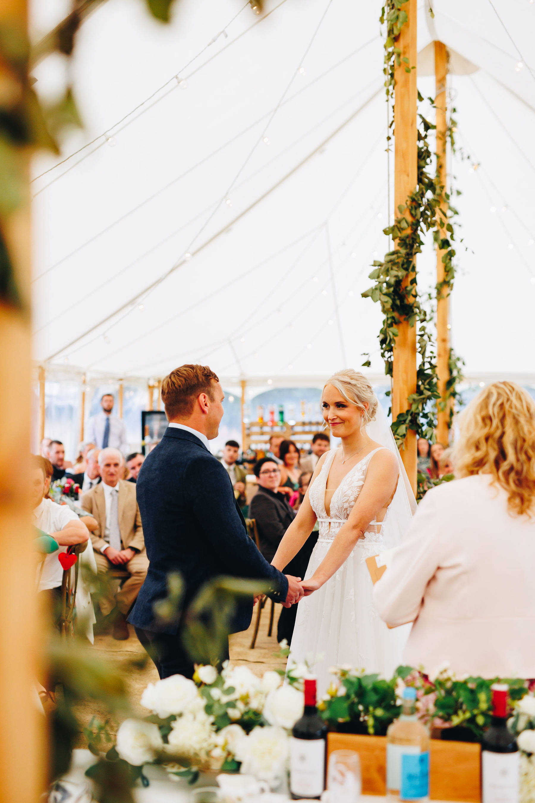 Bride and groom during wedding ceremony inside marquee