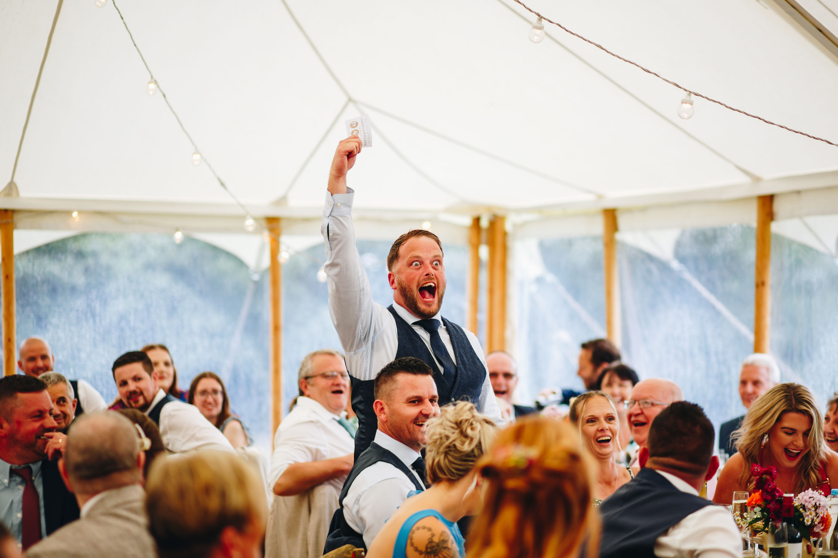 Guest cheers after winning game at wedding reception