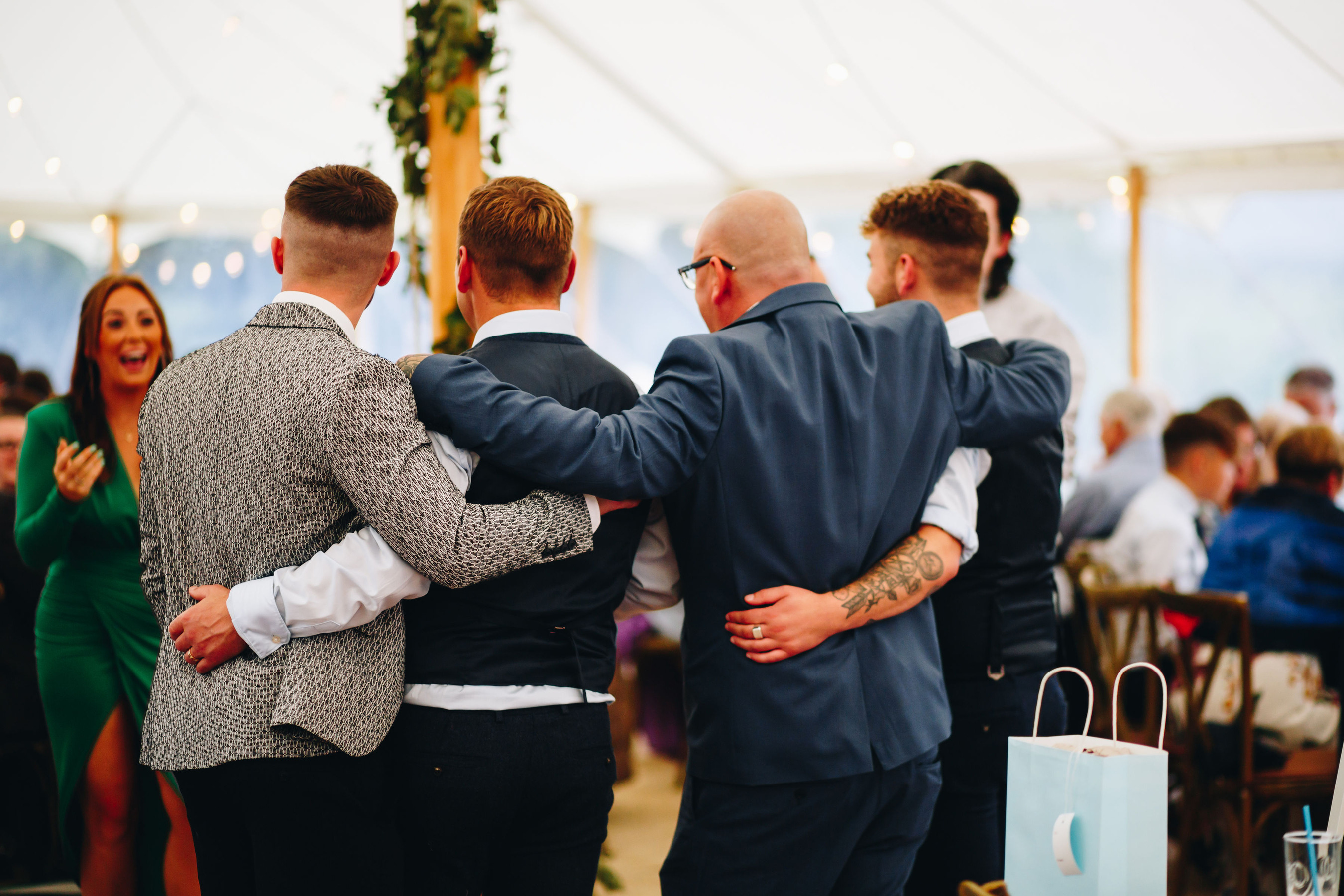 Guests smile for a photo, arm in arm