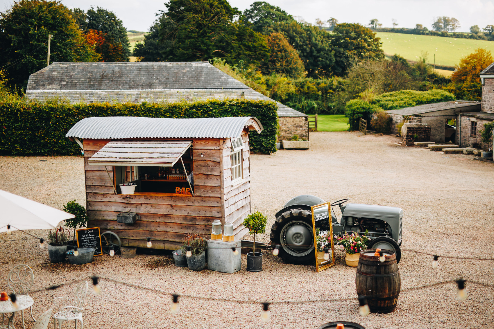 The wooden Shepards Hut bar with a tractor in a courtyard