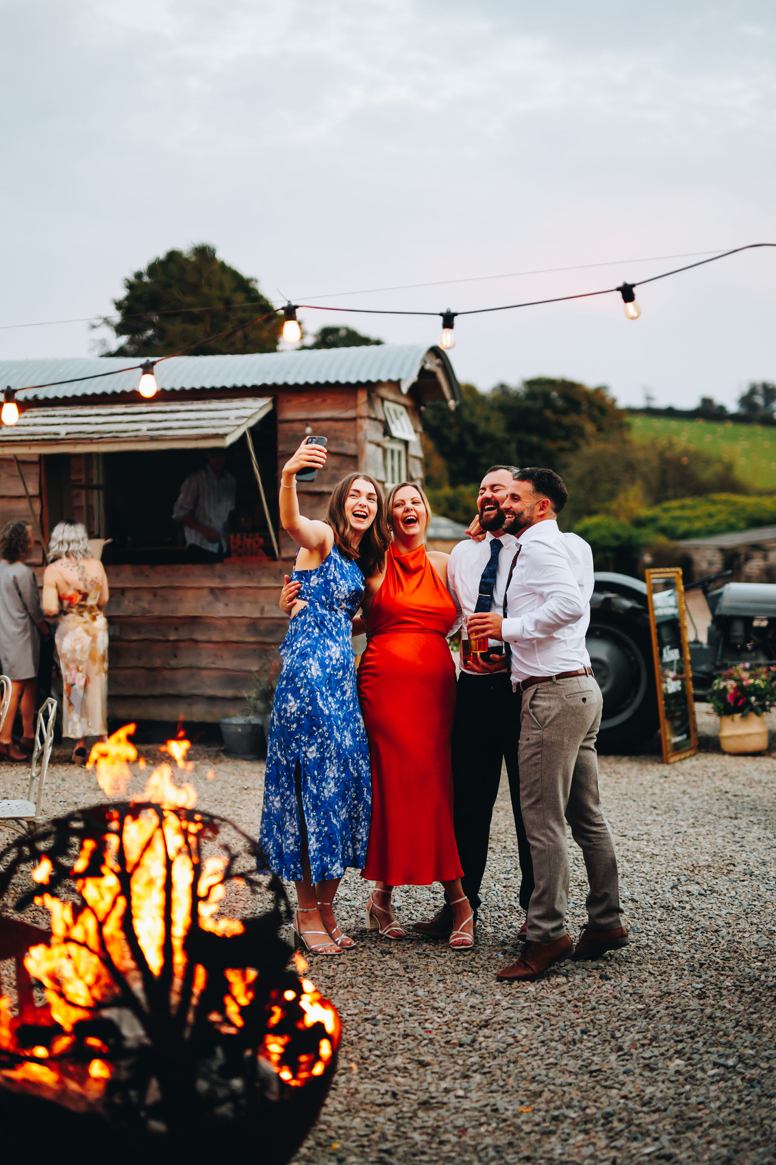 Guests taking a selfie by a fire pit