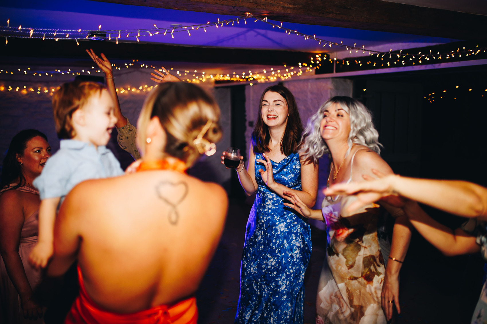 Wedding guests partying with fairy lights adorning the ceiling