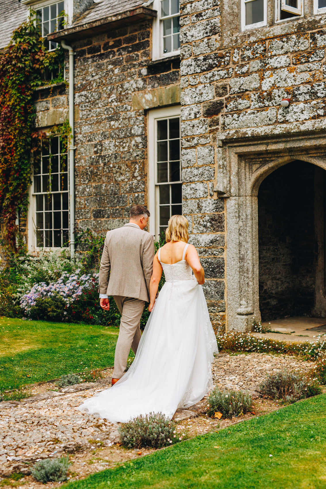 Just married couple walking into manor home