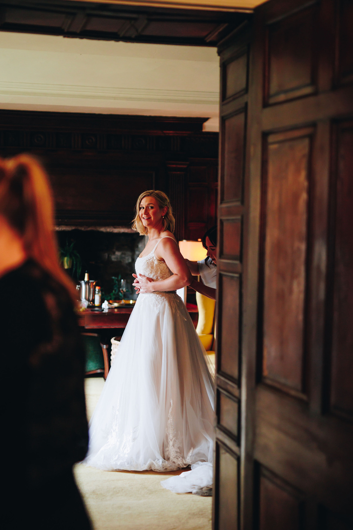 Bride's gown being done up in the next room