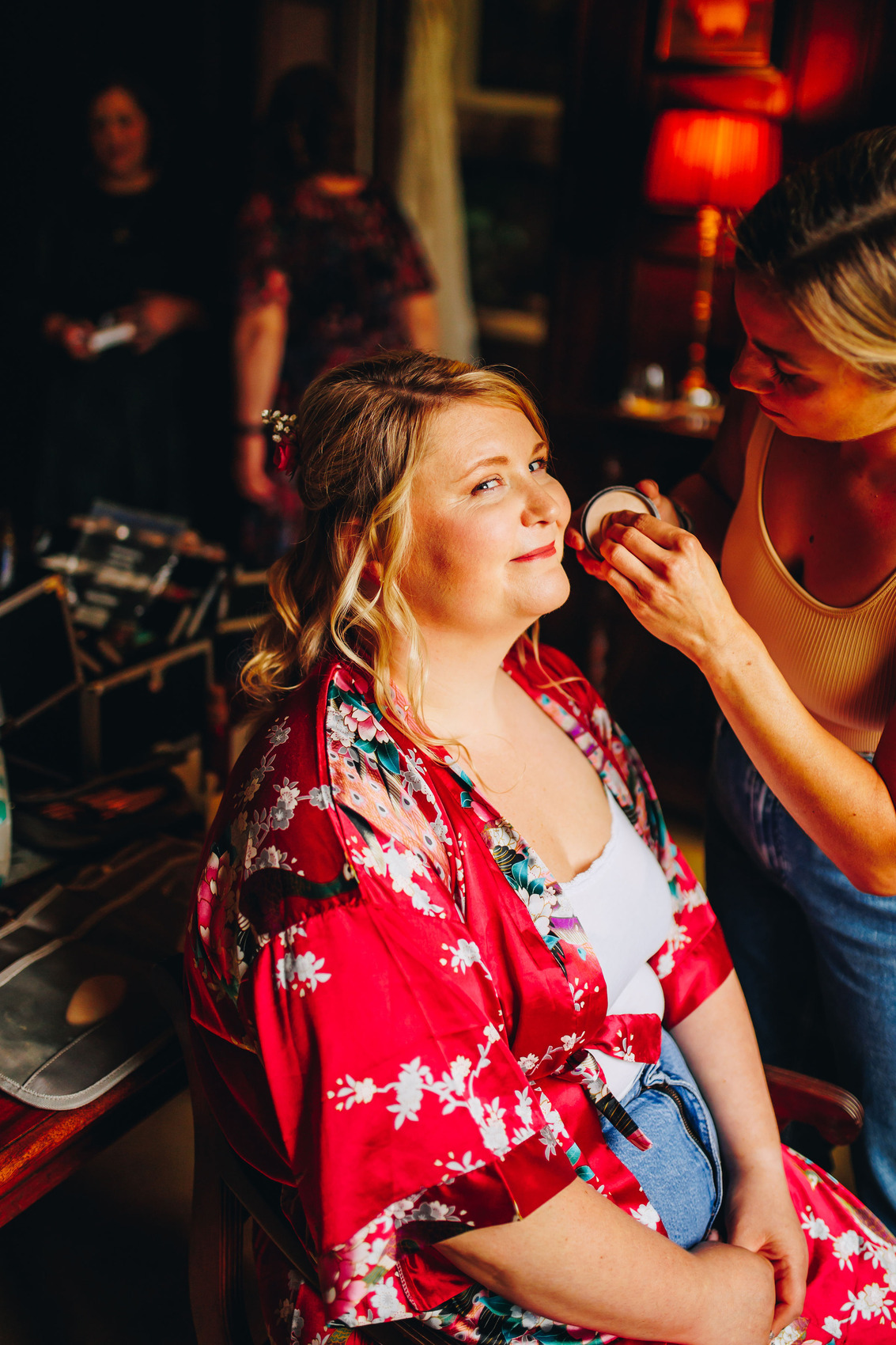 Bride having make up done, wearing a pink robe