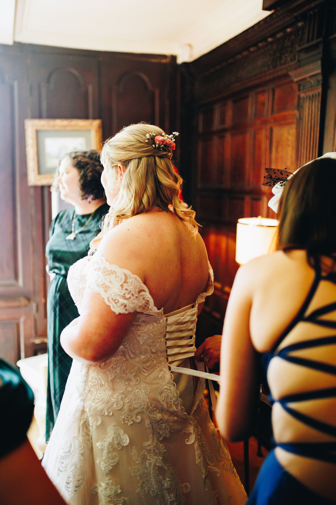 Bride getting dress corset back done up