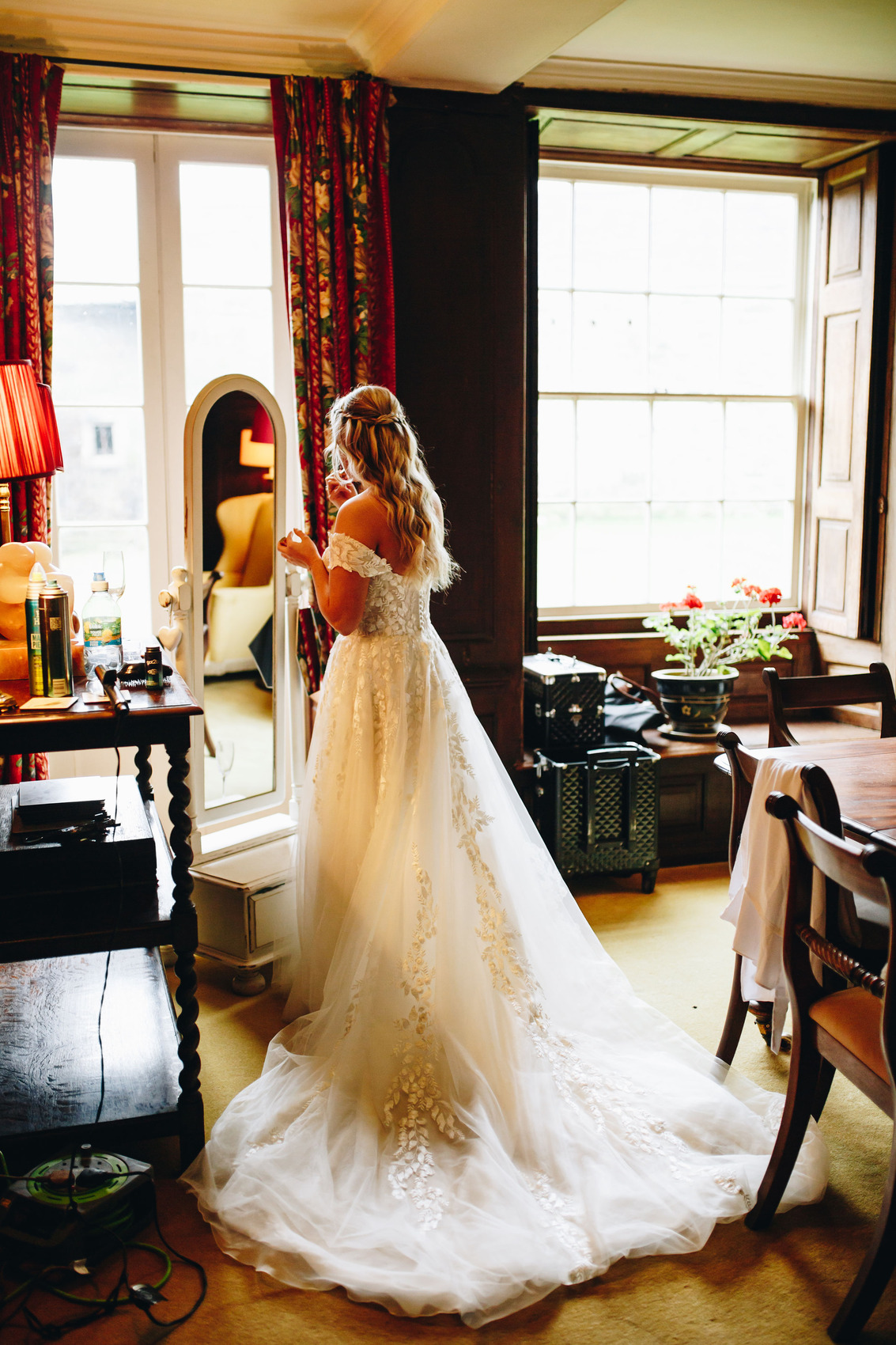Bride in wedding dress fixing make up in mirror