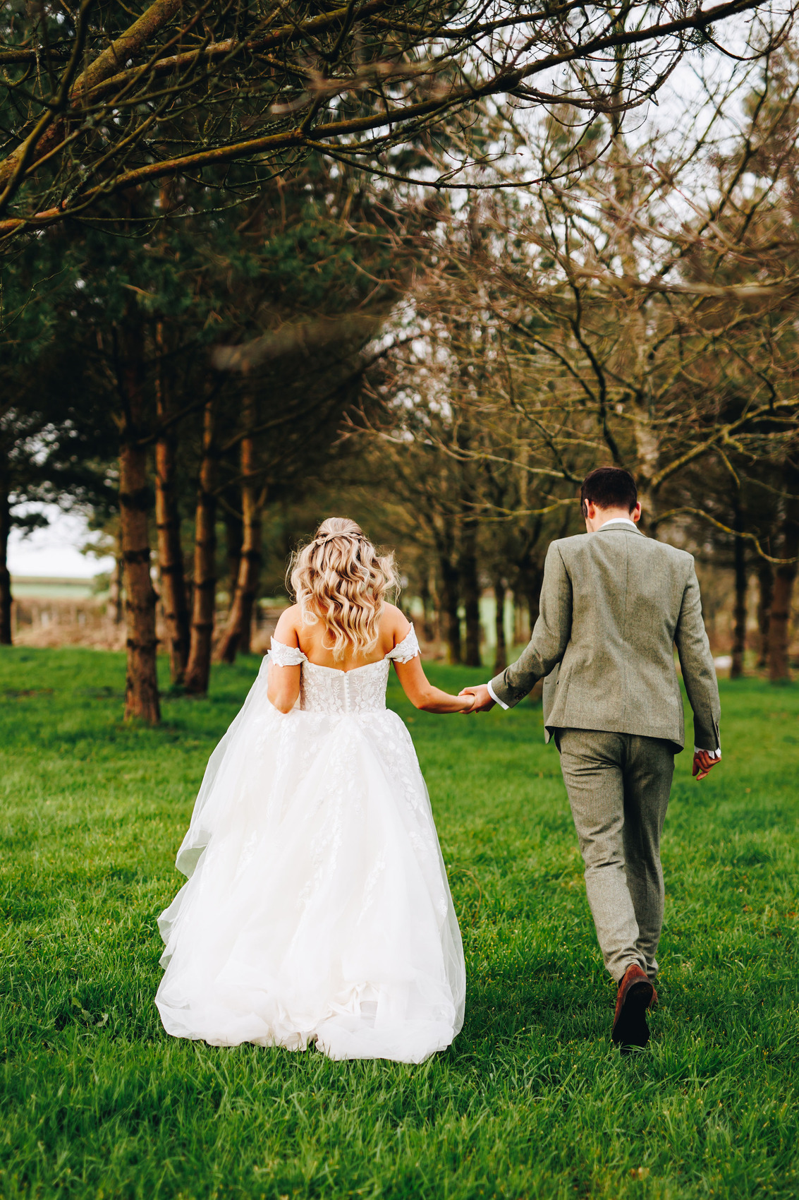 Couple walking away, towards trees and grass