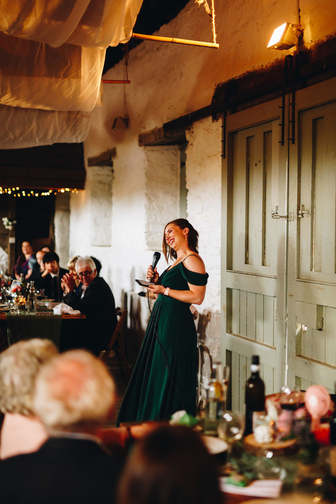 Bridesmaid in a green dress giving a speech