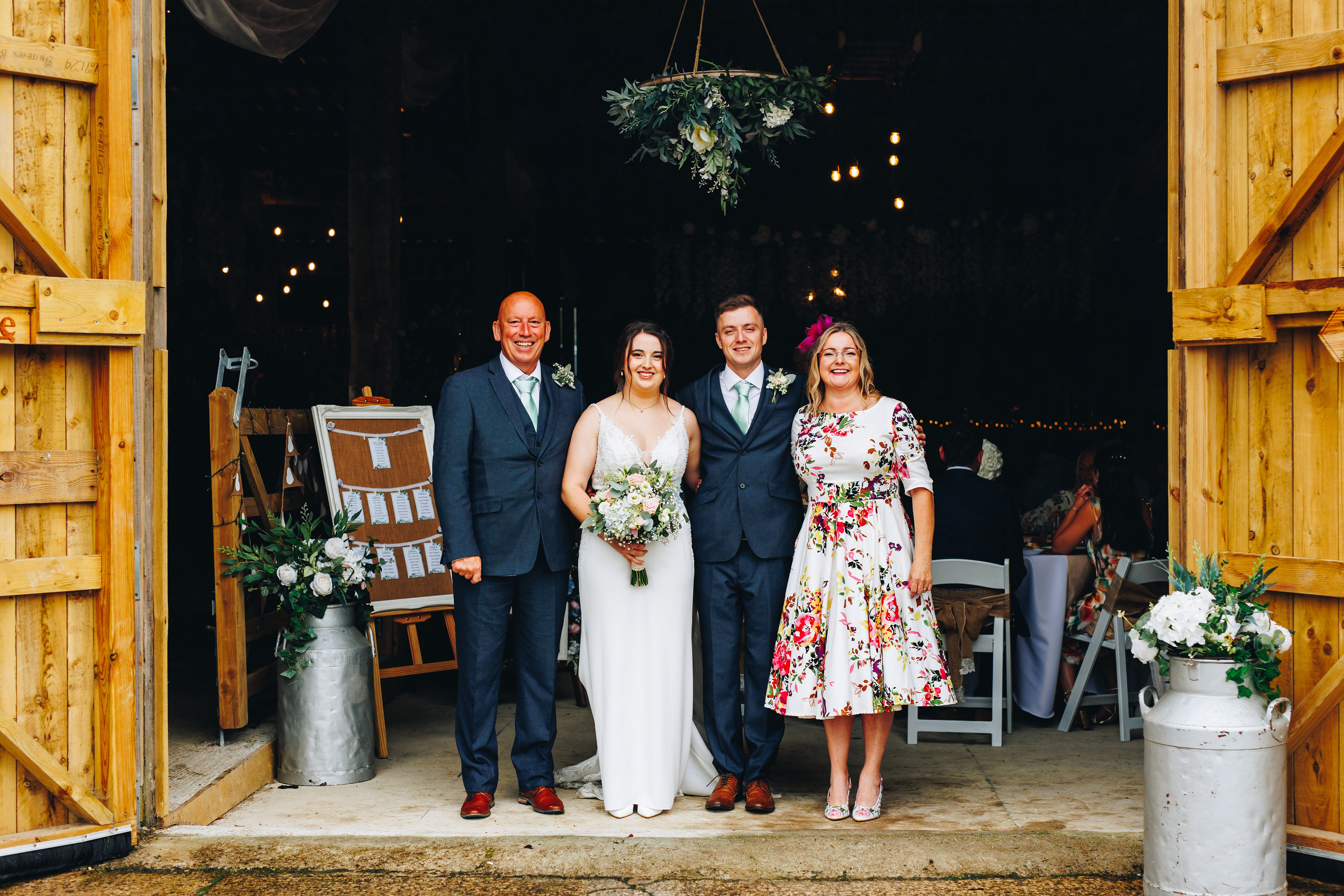 Family photo with bride and groom in barn entrance