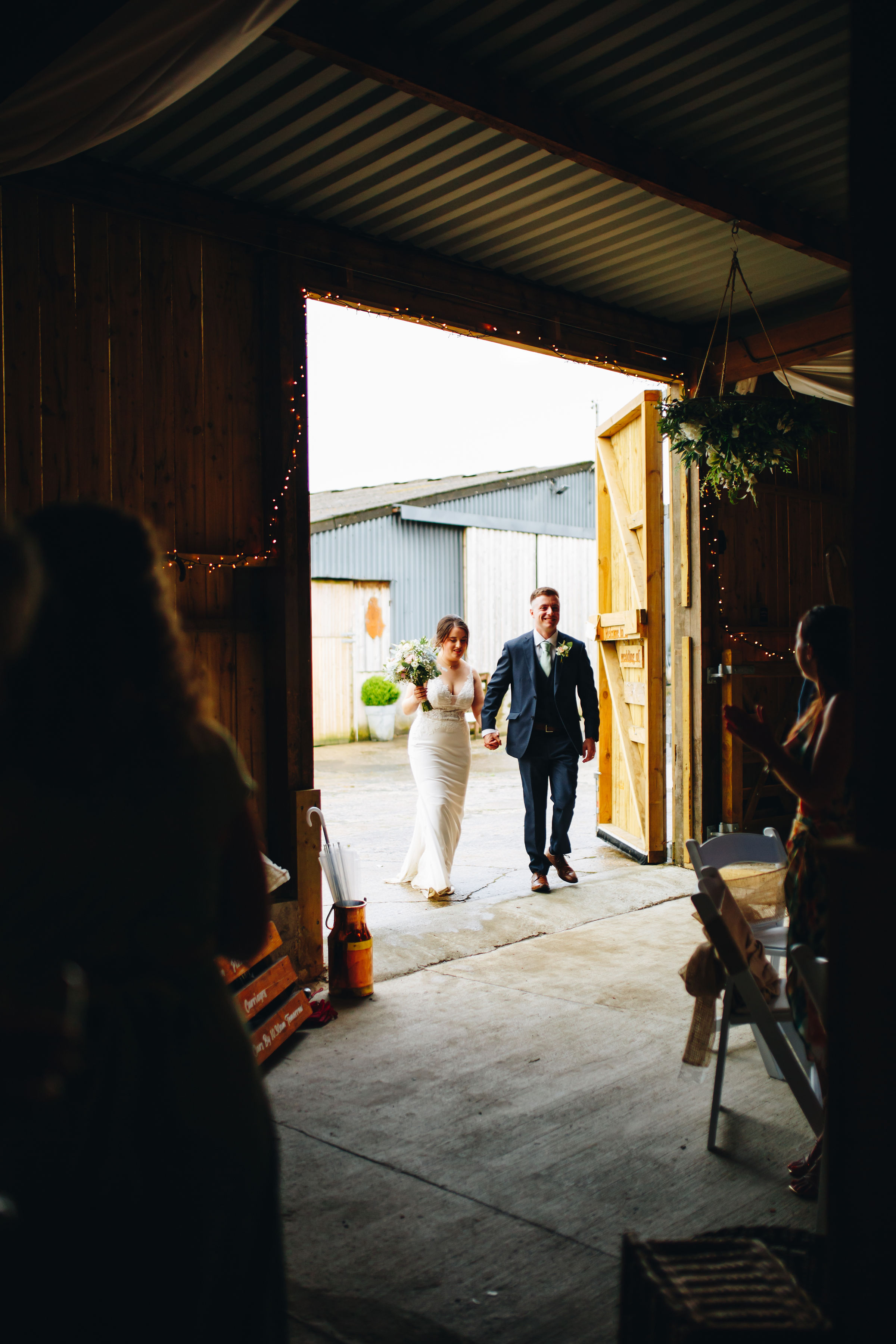 Couple walking into dark barn