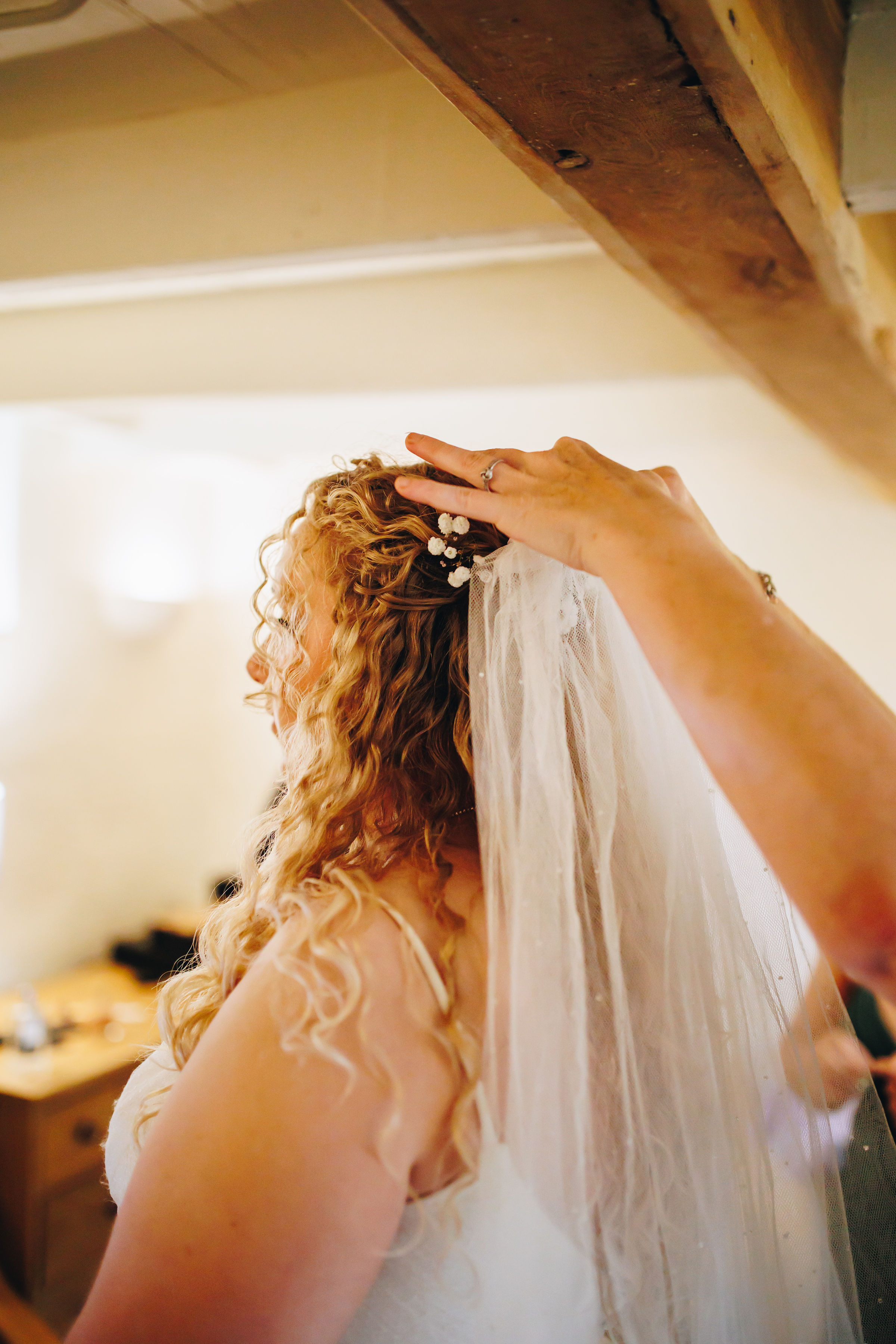 Bride with curly blonde hair gets veil put in