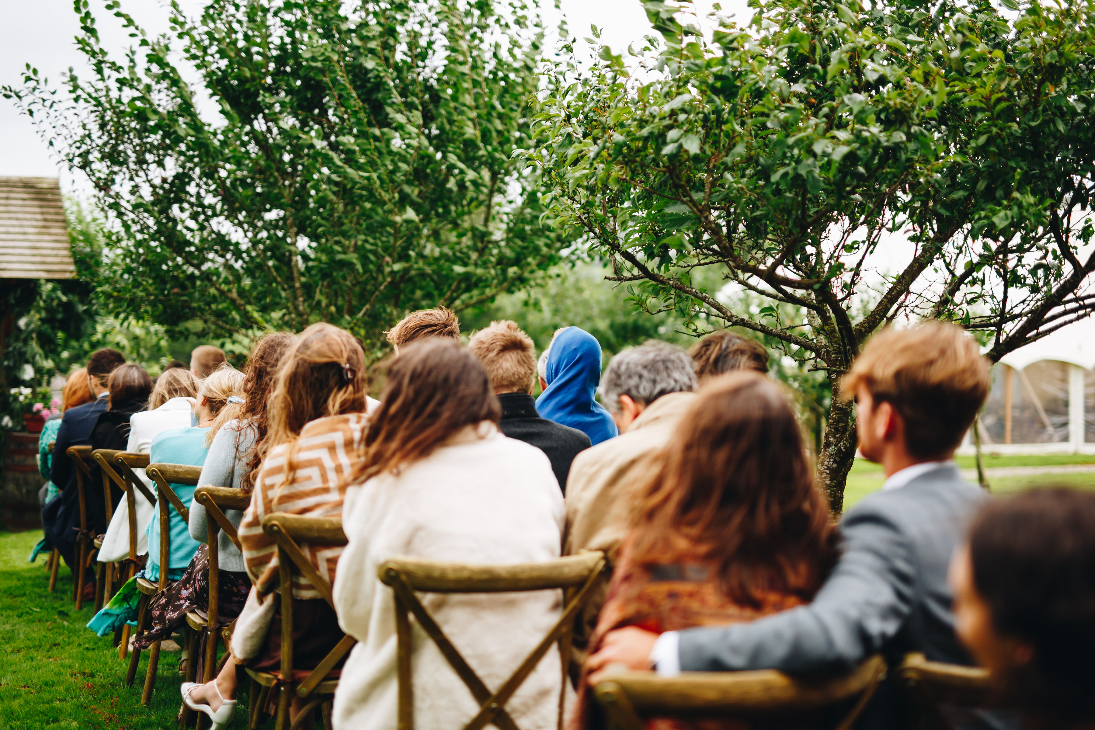 Photo of guests from the back, covered with shawls in the wind