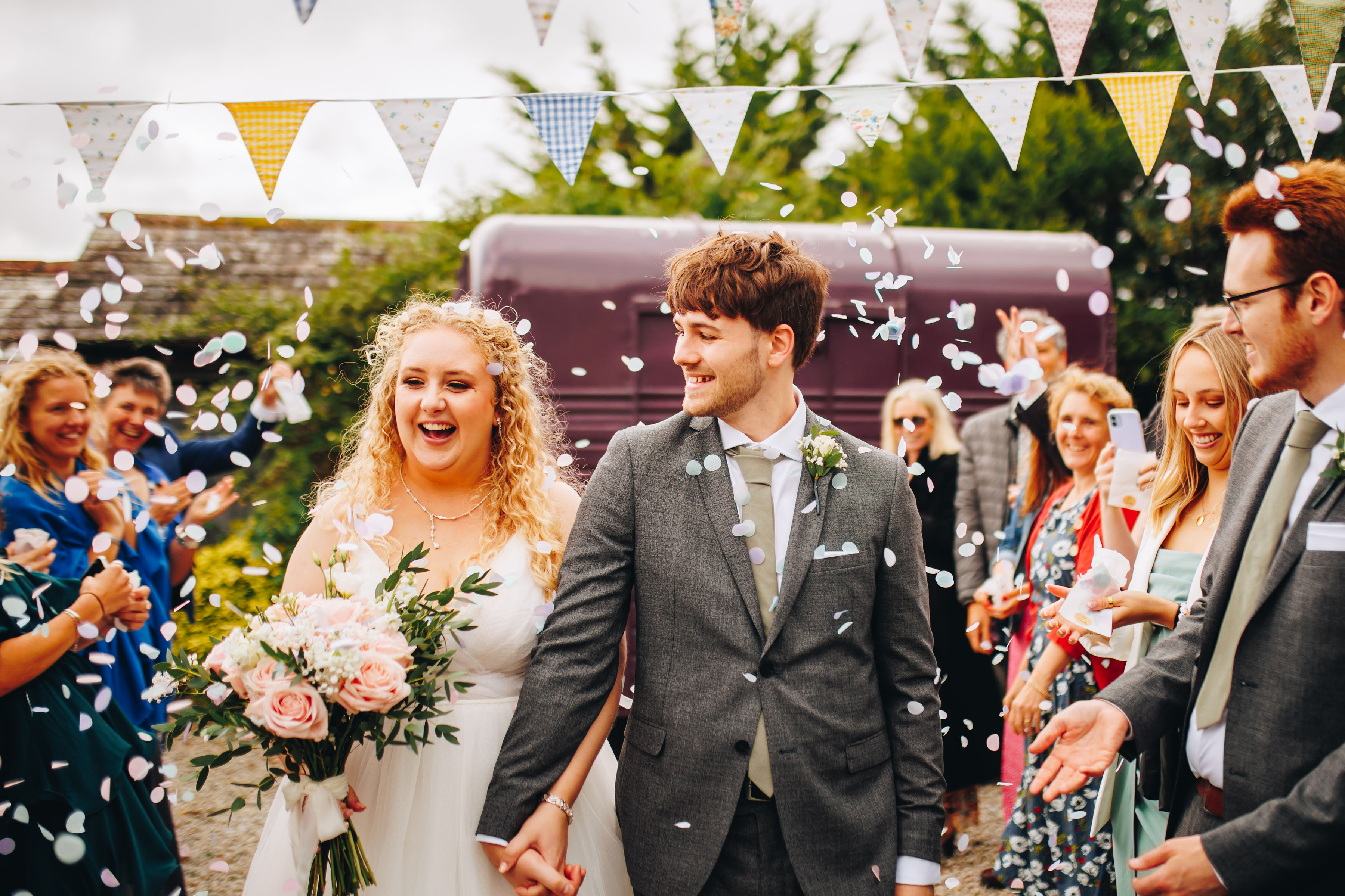 Confetti walk with wedding couple smiling hand in hand