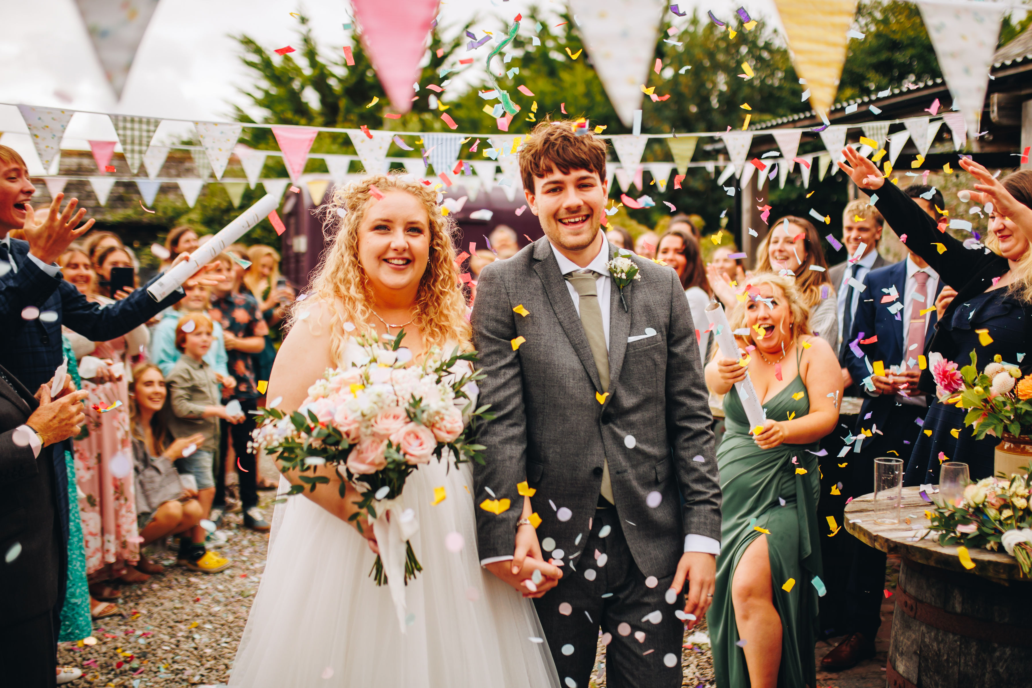 Confetti walk with wedding couple smiling hand in hand