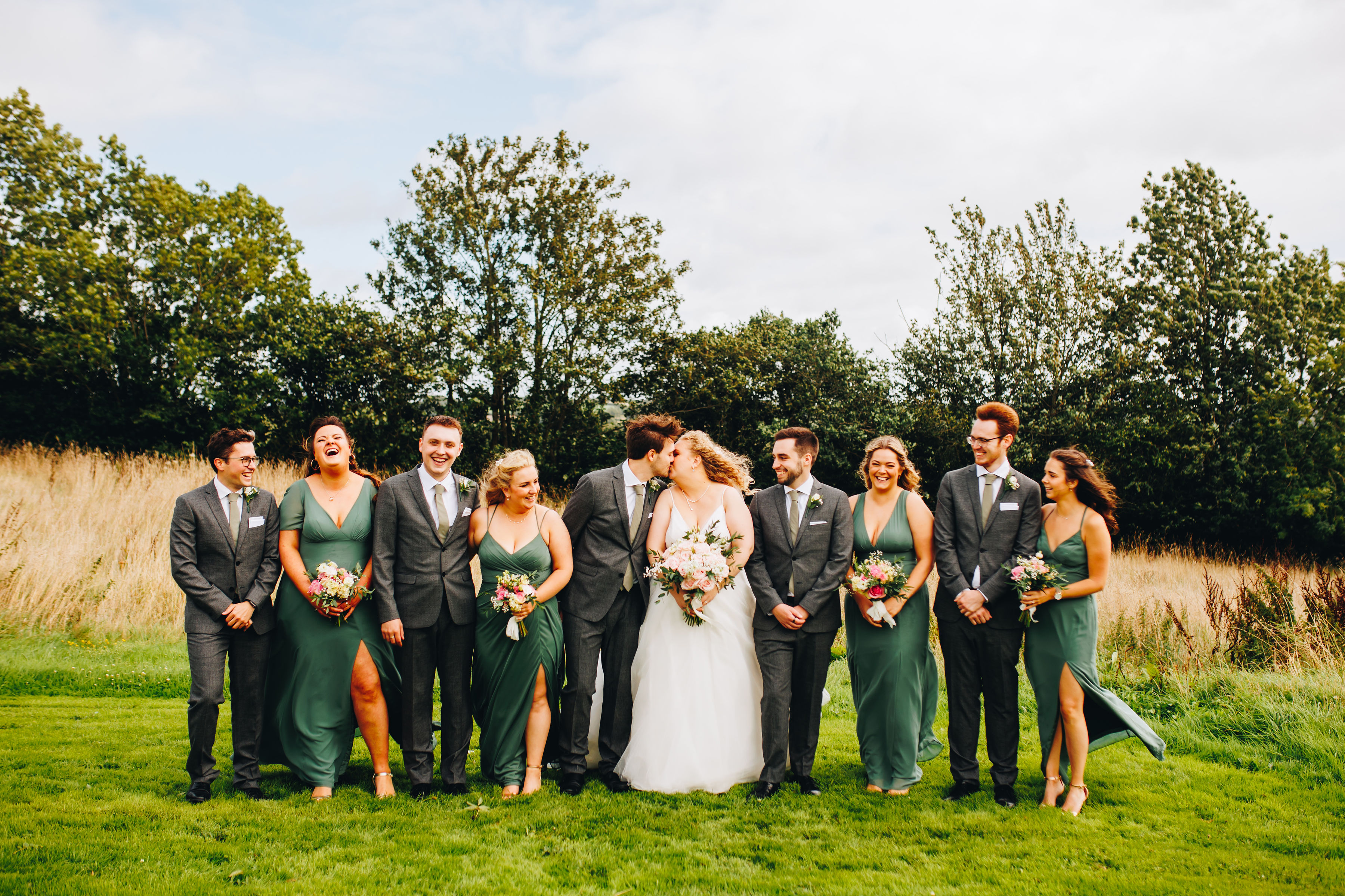 Group photo of wedding party in field