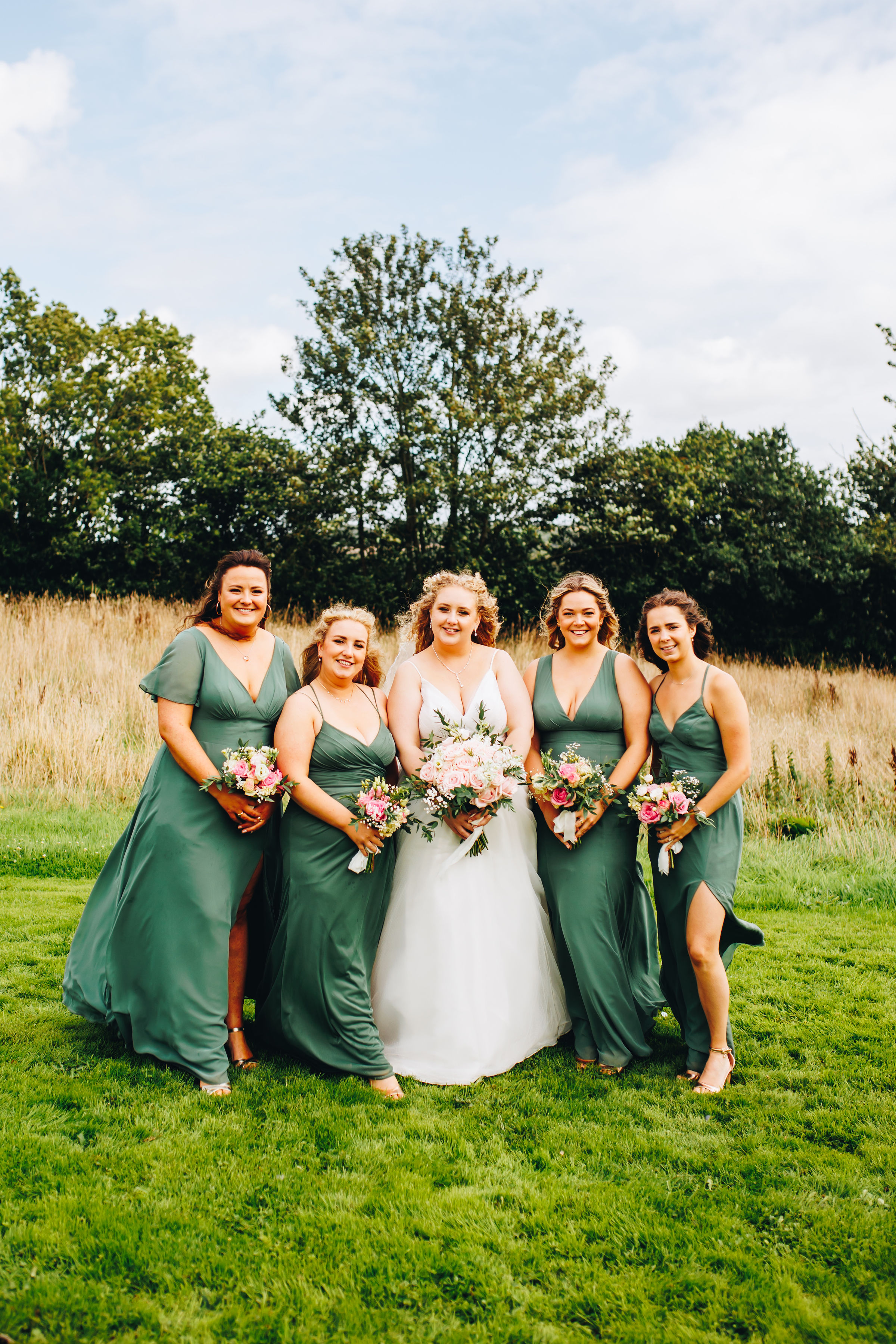 Group photo of wedding party in field