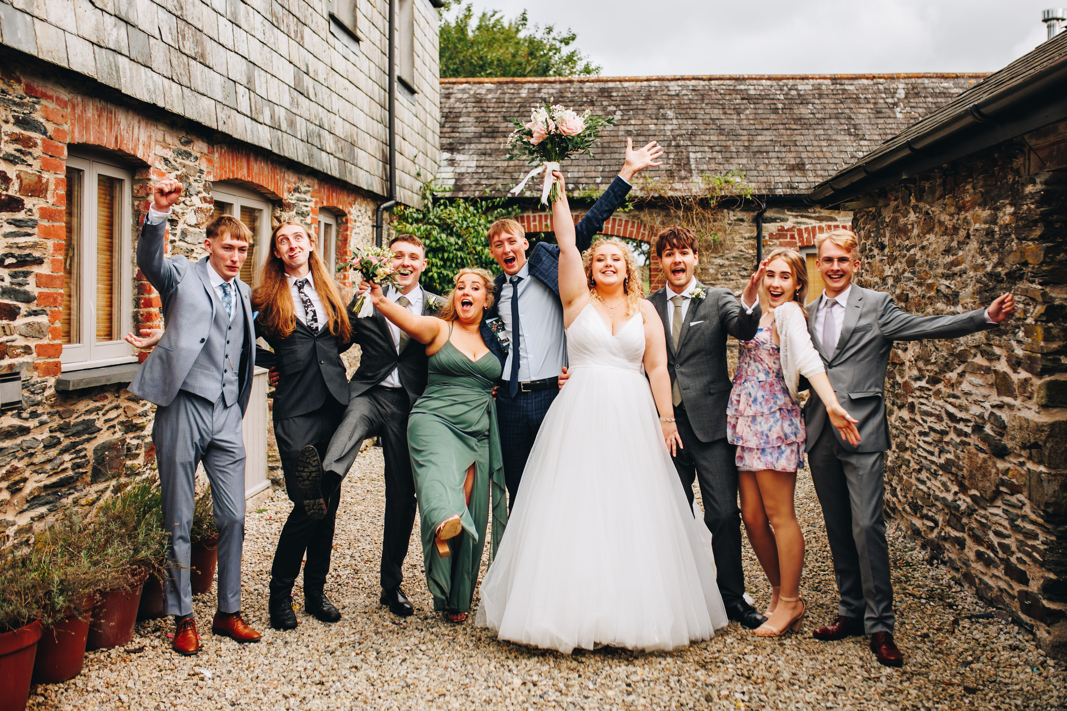 Group photo of wedding party in a rustic courtyard