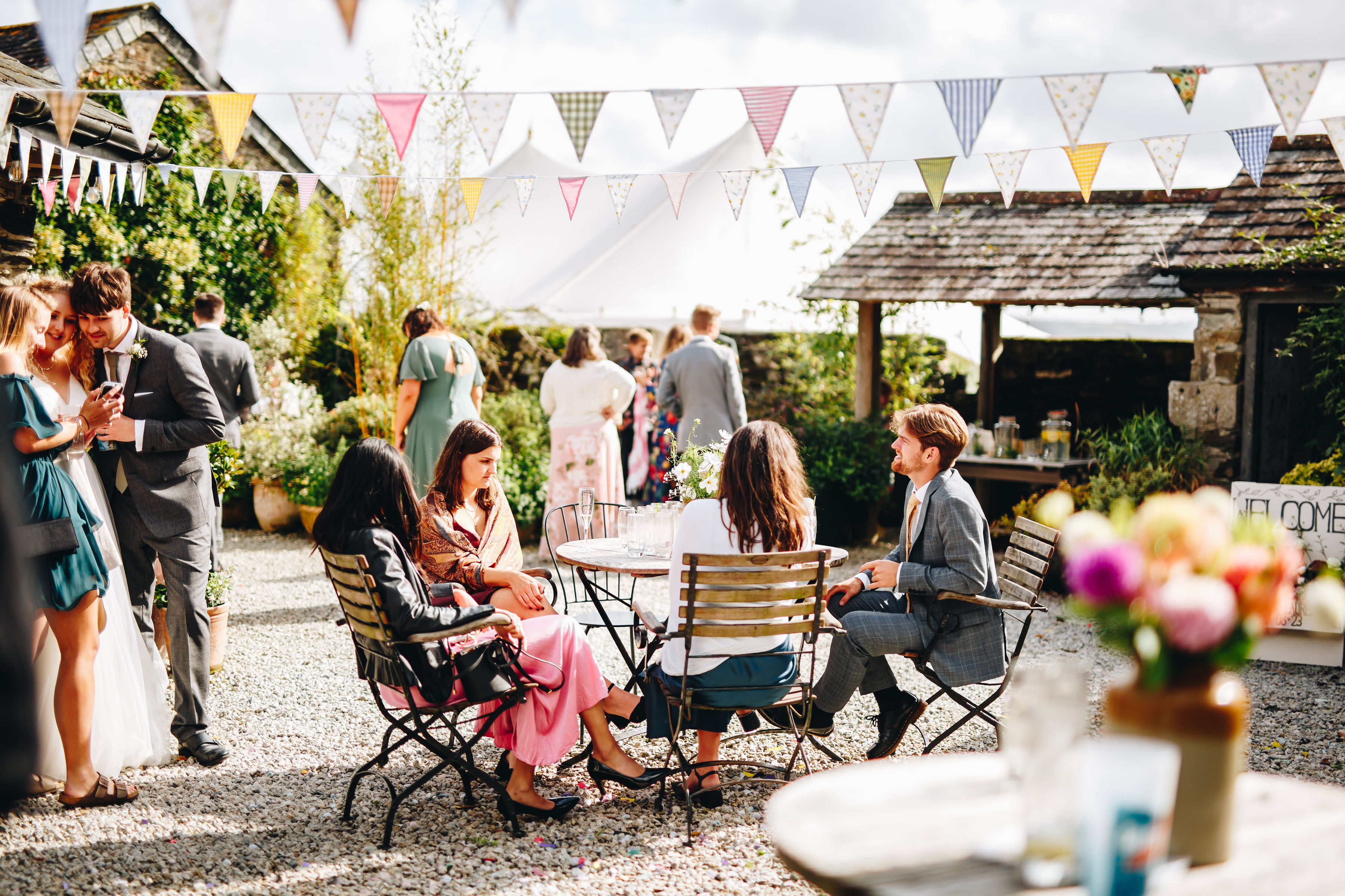Courtyard wedding reception with guests sat around chatting