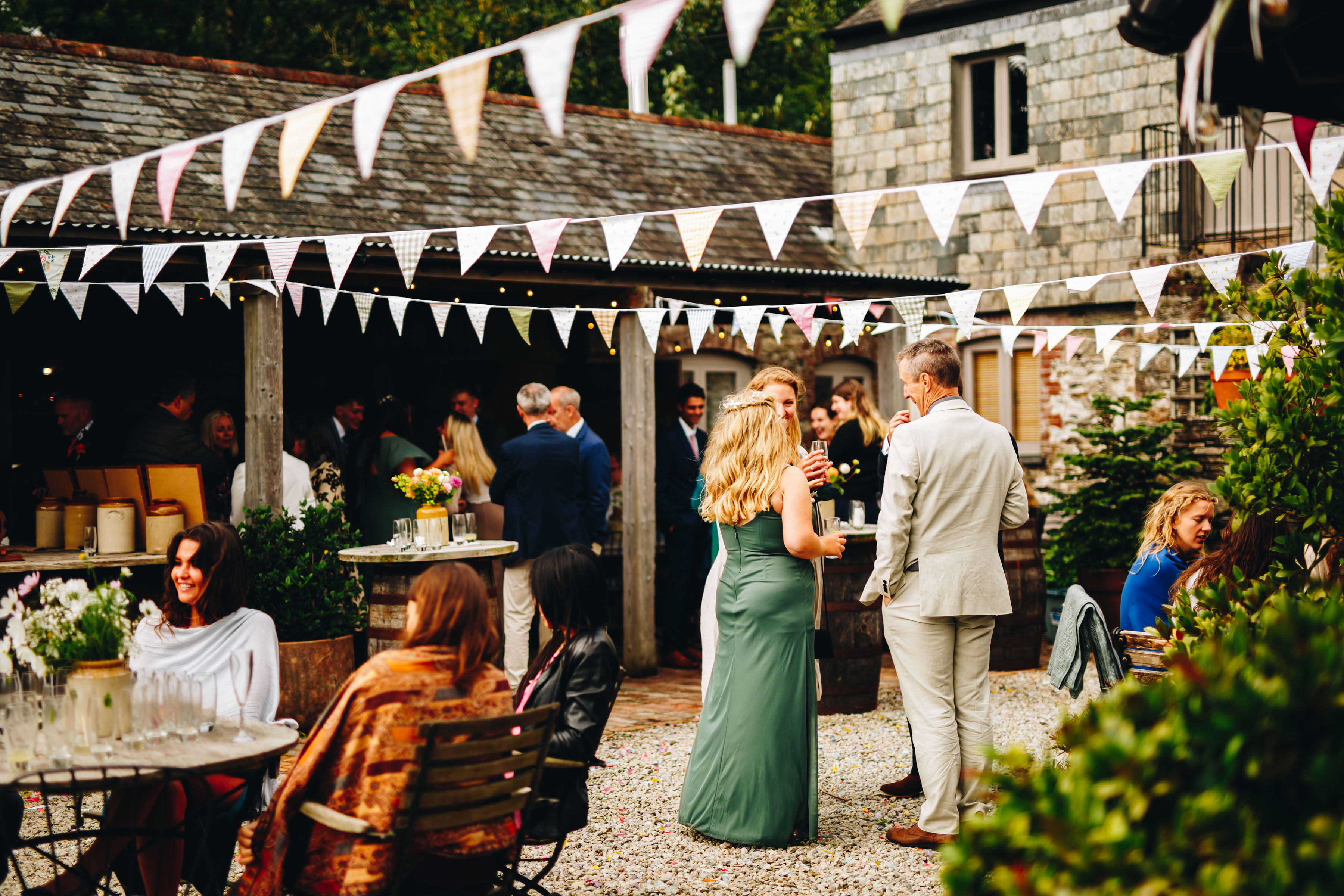 Courtyard wedding reception with guests sat around chatting