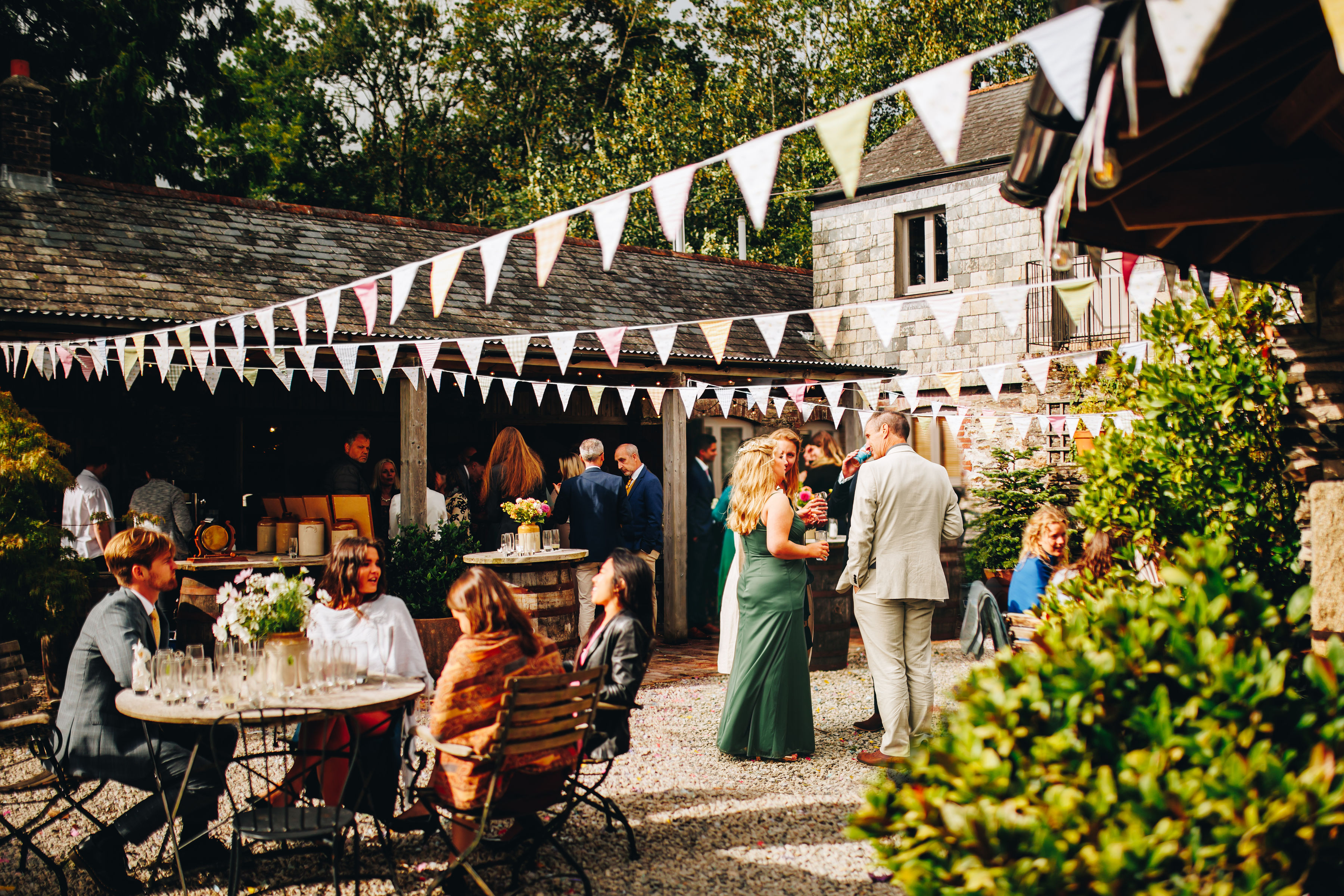 Courtyard wedding reception with guests sat around chatting