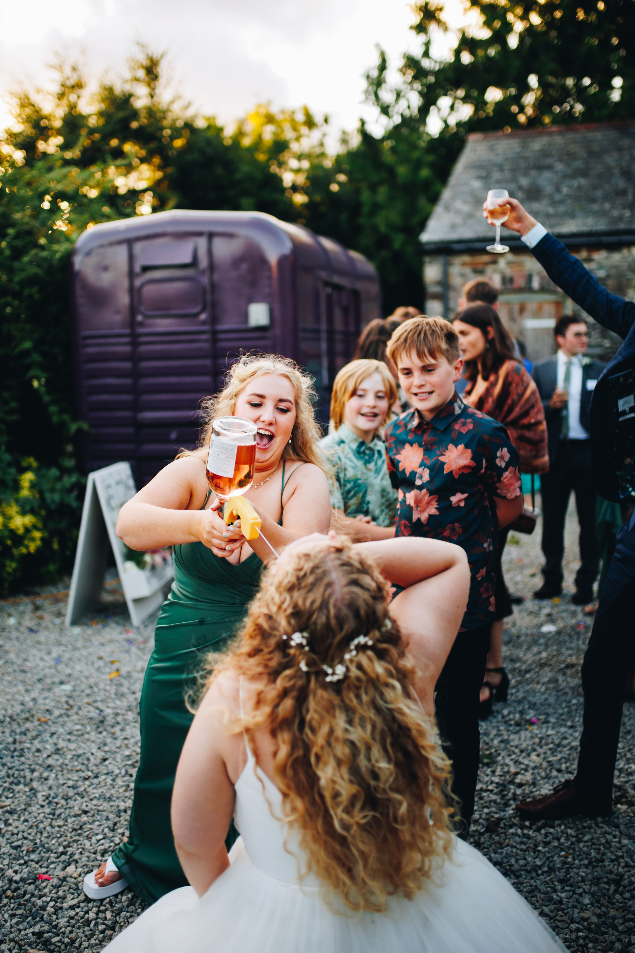Bridesmaid using Prosecco gun