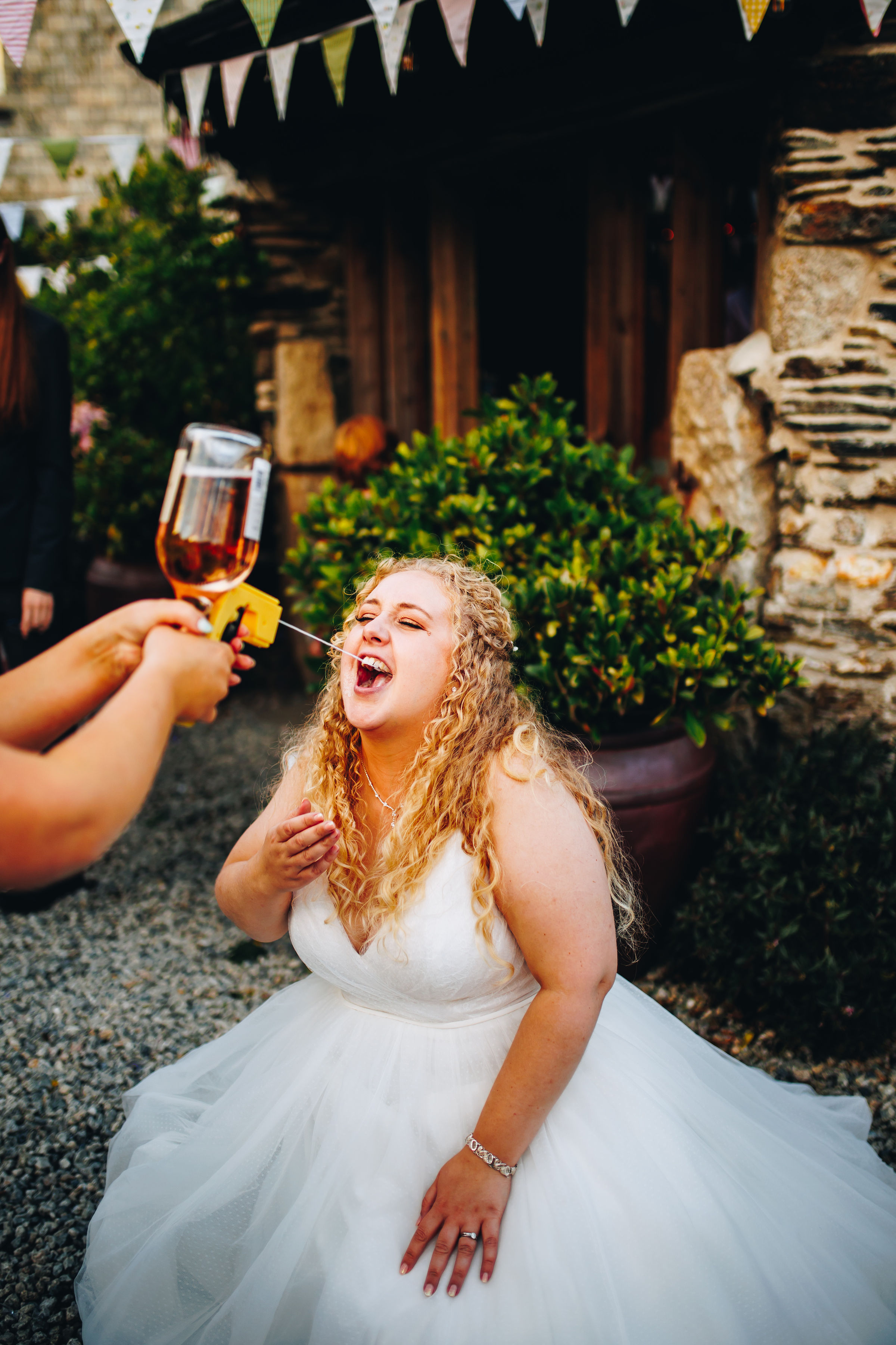 Bridesmaid using Prosecco gun