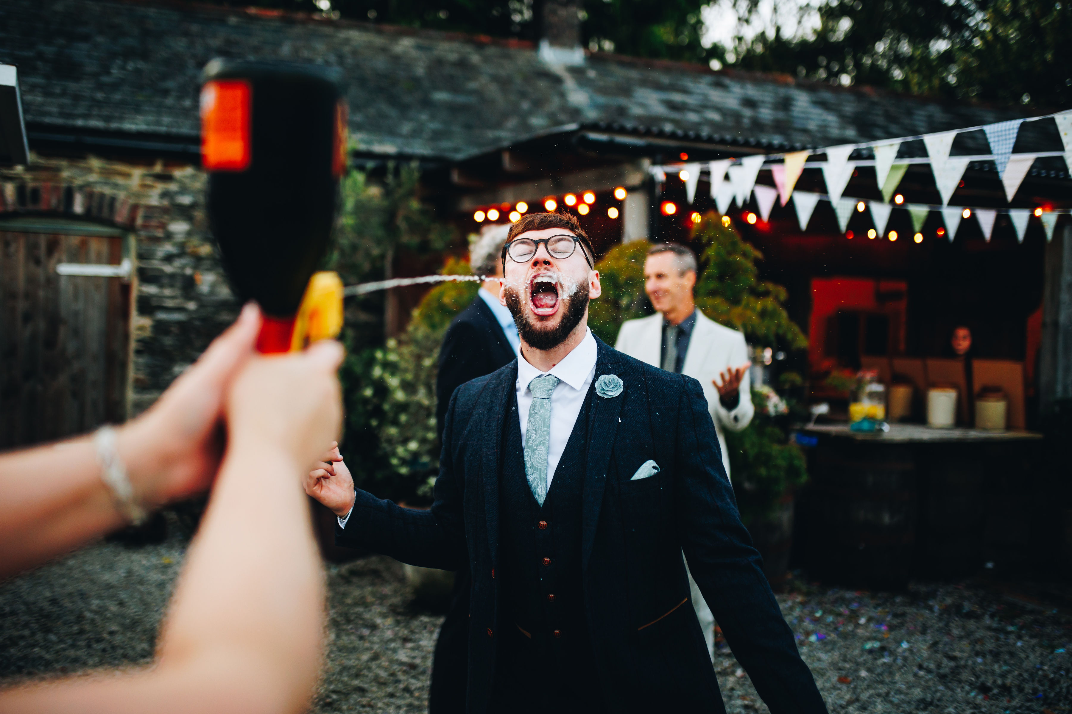 Bridesmaid using Prosecco gun