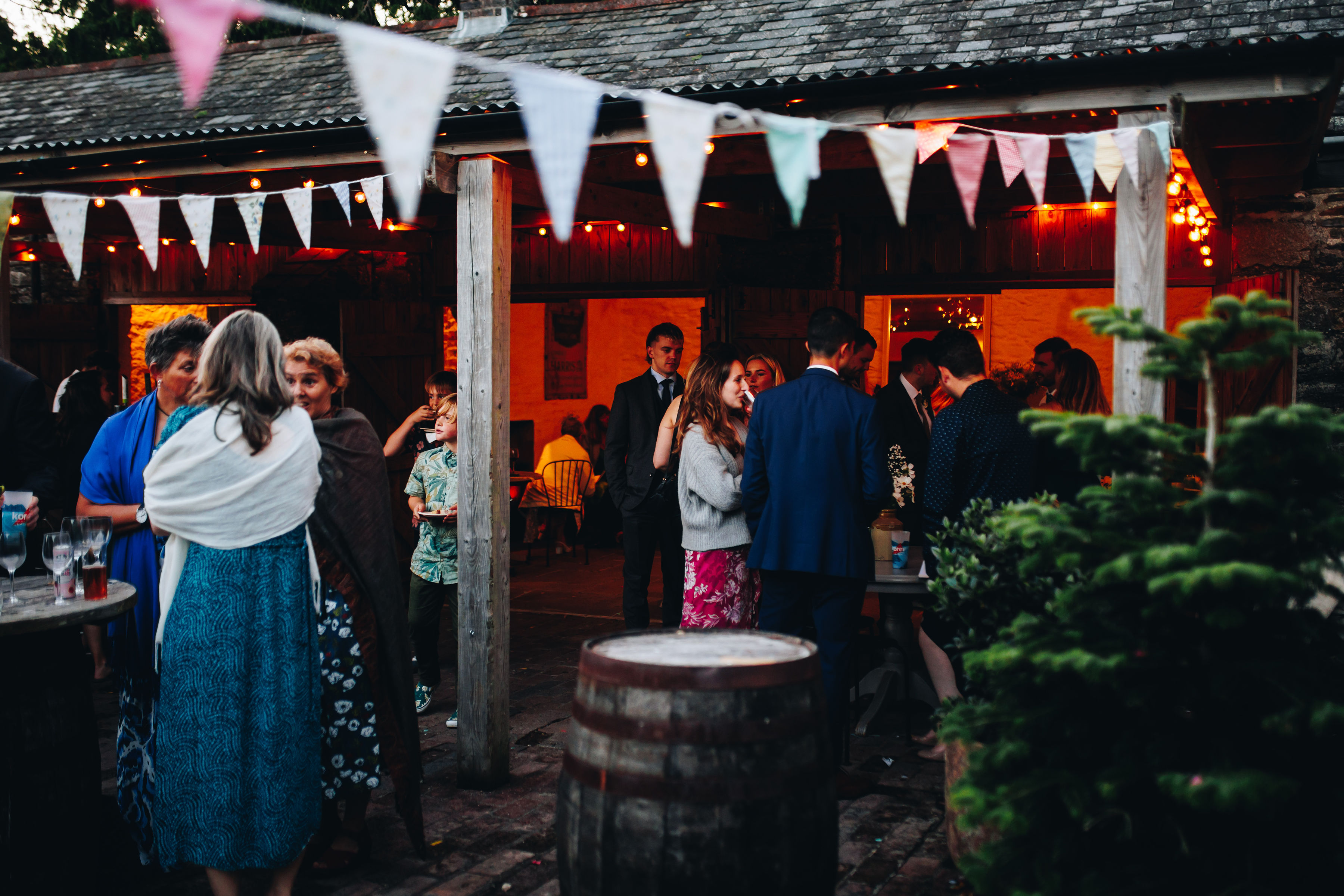 Guests stood around chatting outside under bunting