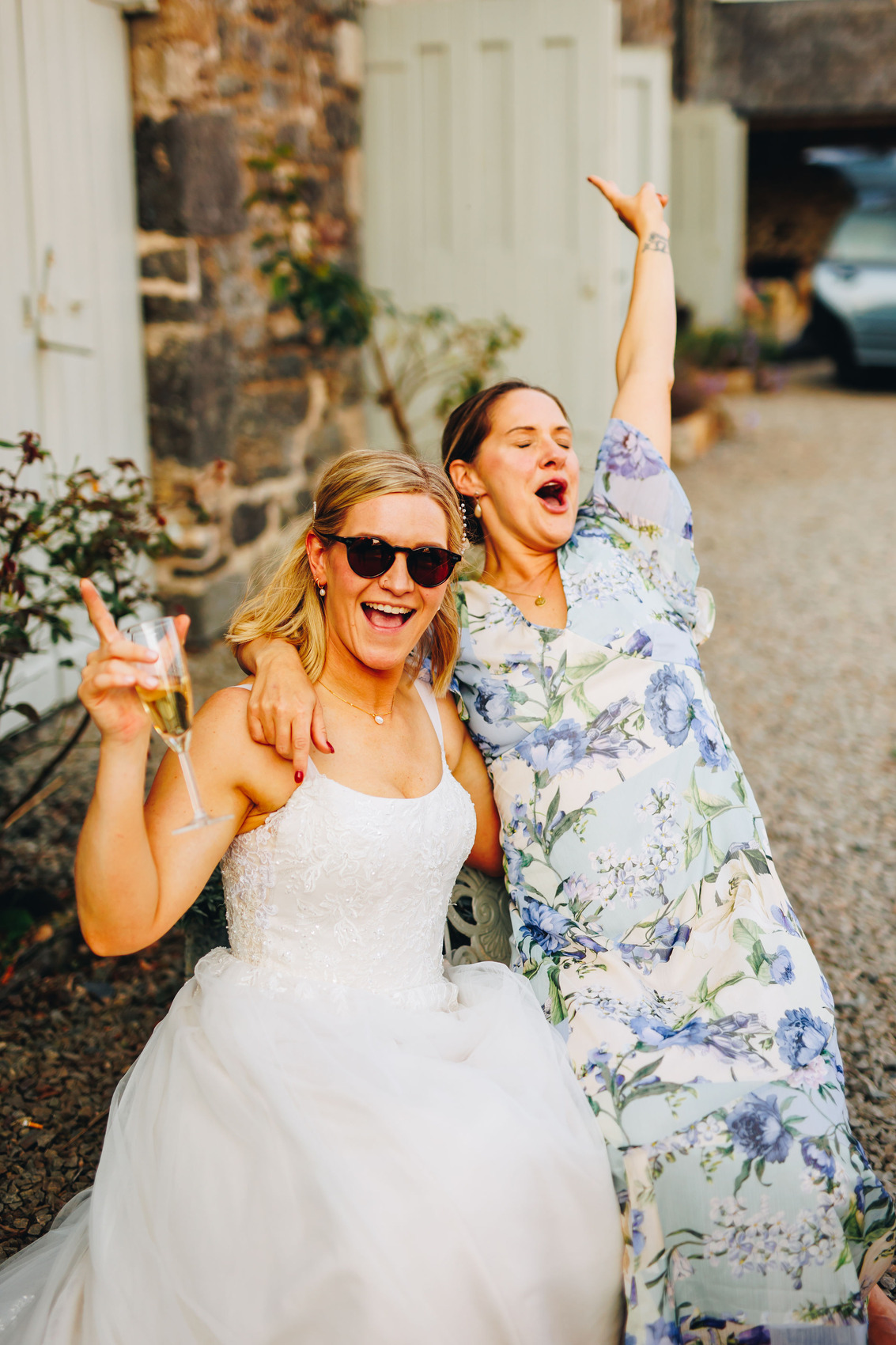 Bride and guest cheering in the courtyard of Bradstone Manor