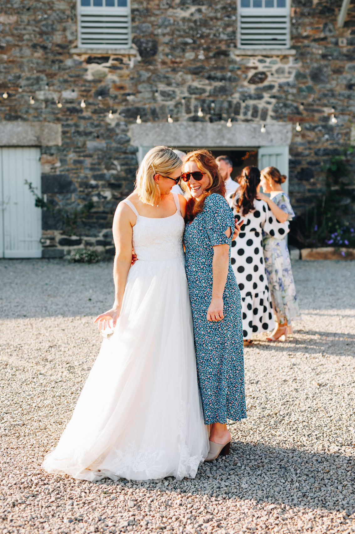 Bride and friend smiling in the sunny evening